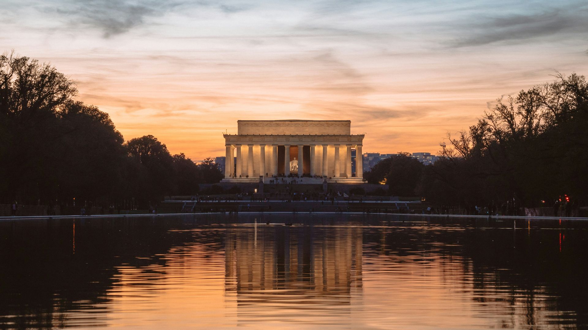 white concrete gazebo near body of water