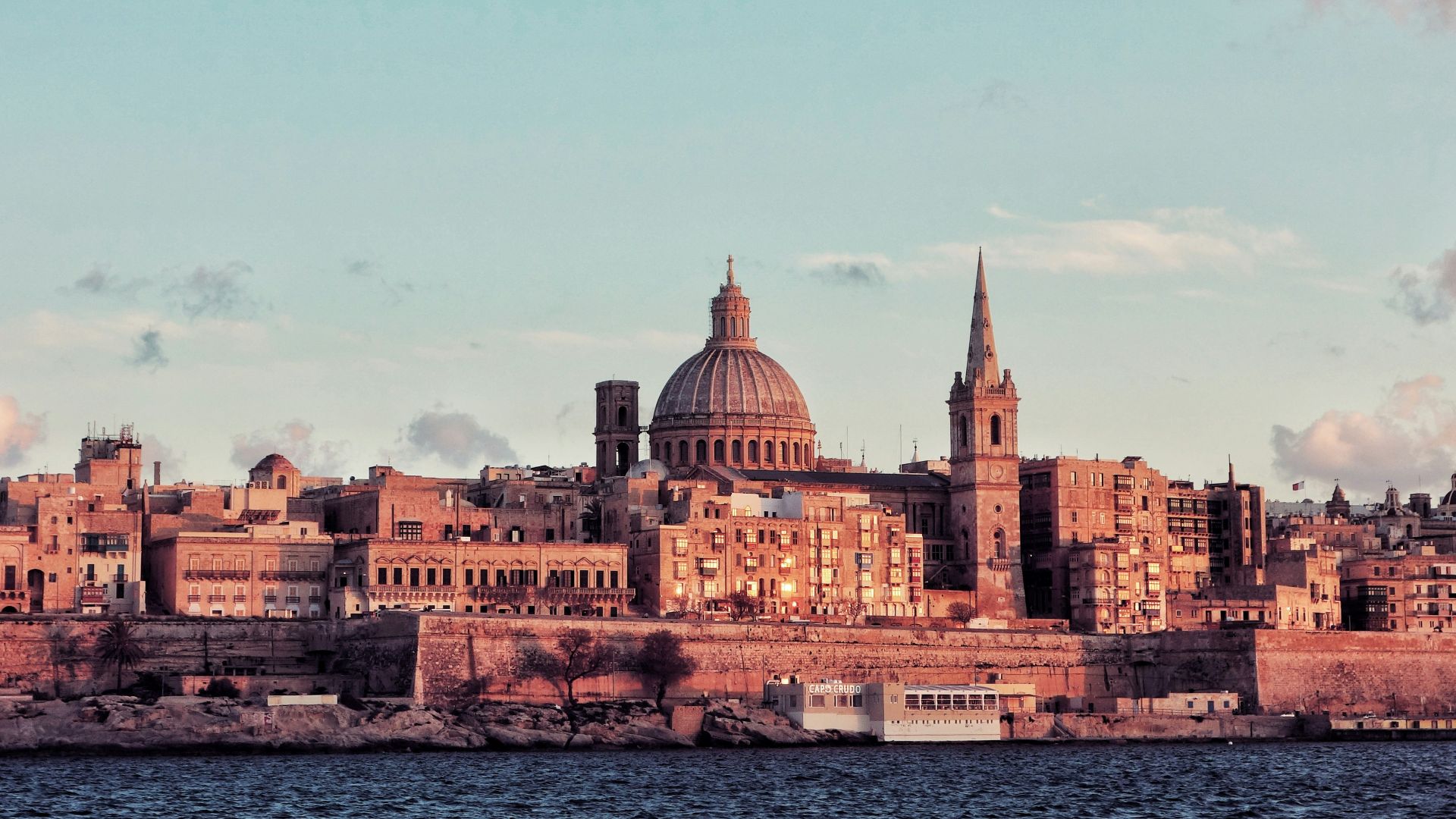 brown concrete dome building near body of water