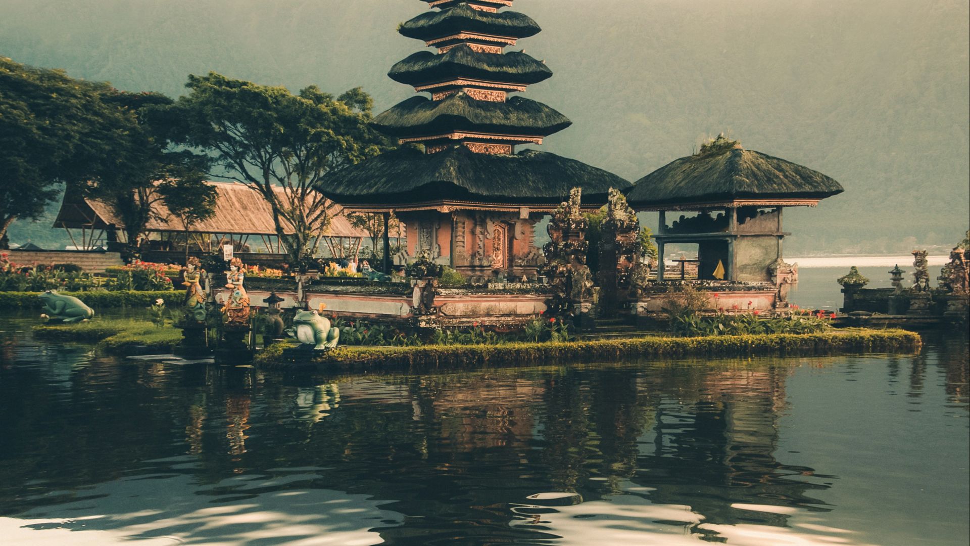 temple beside body of water and trees