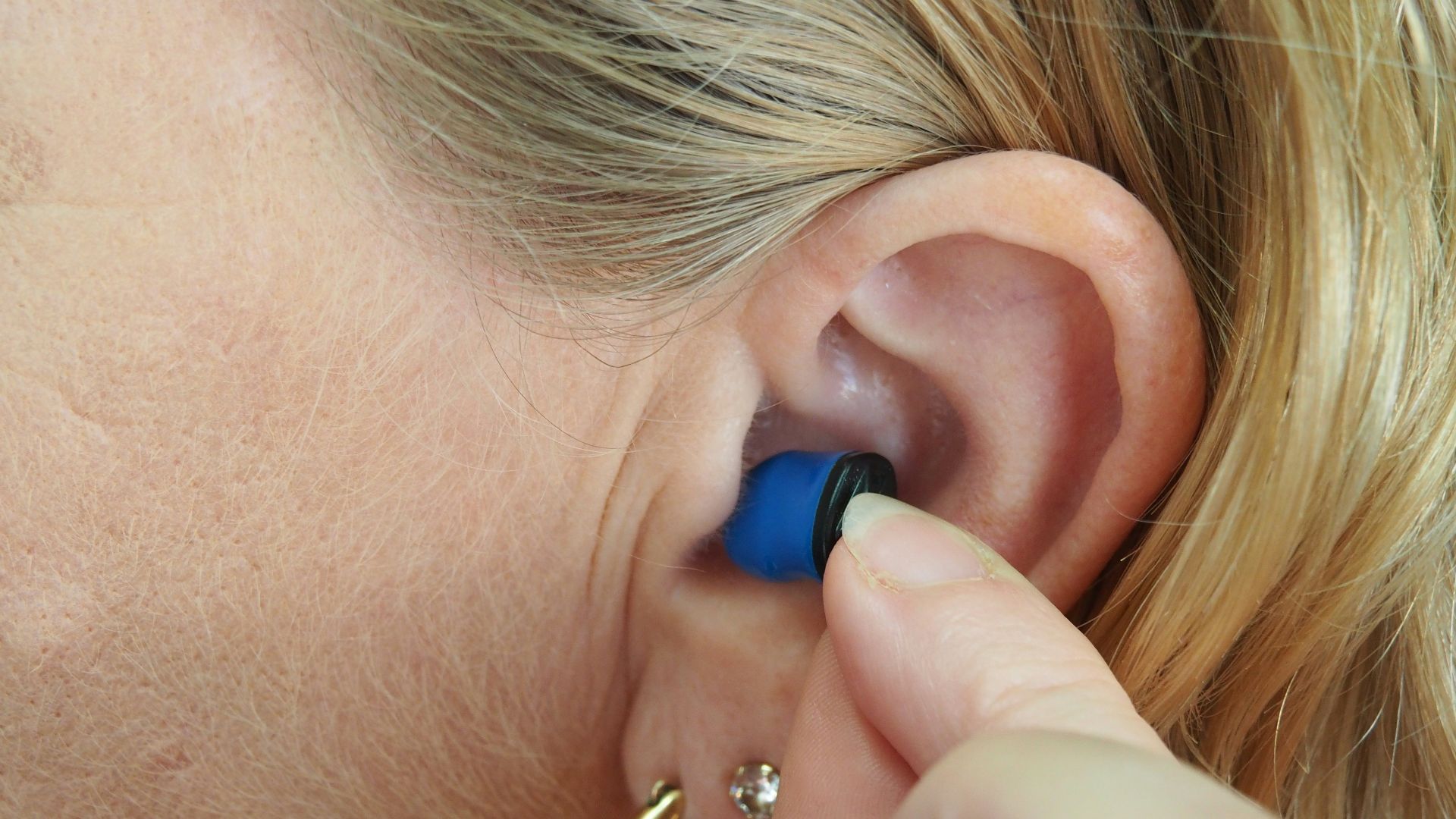 woman wearing blue stud earring