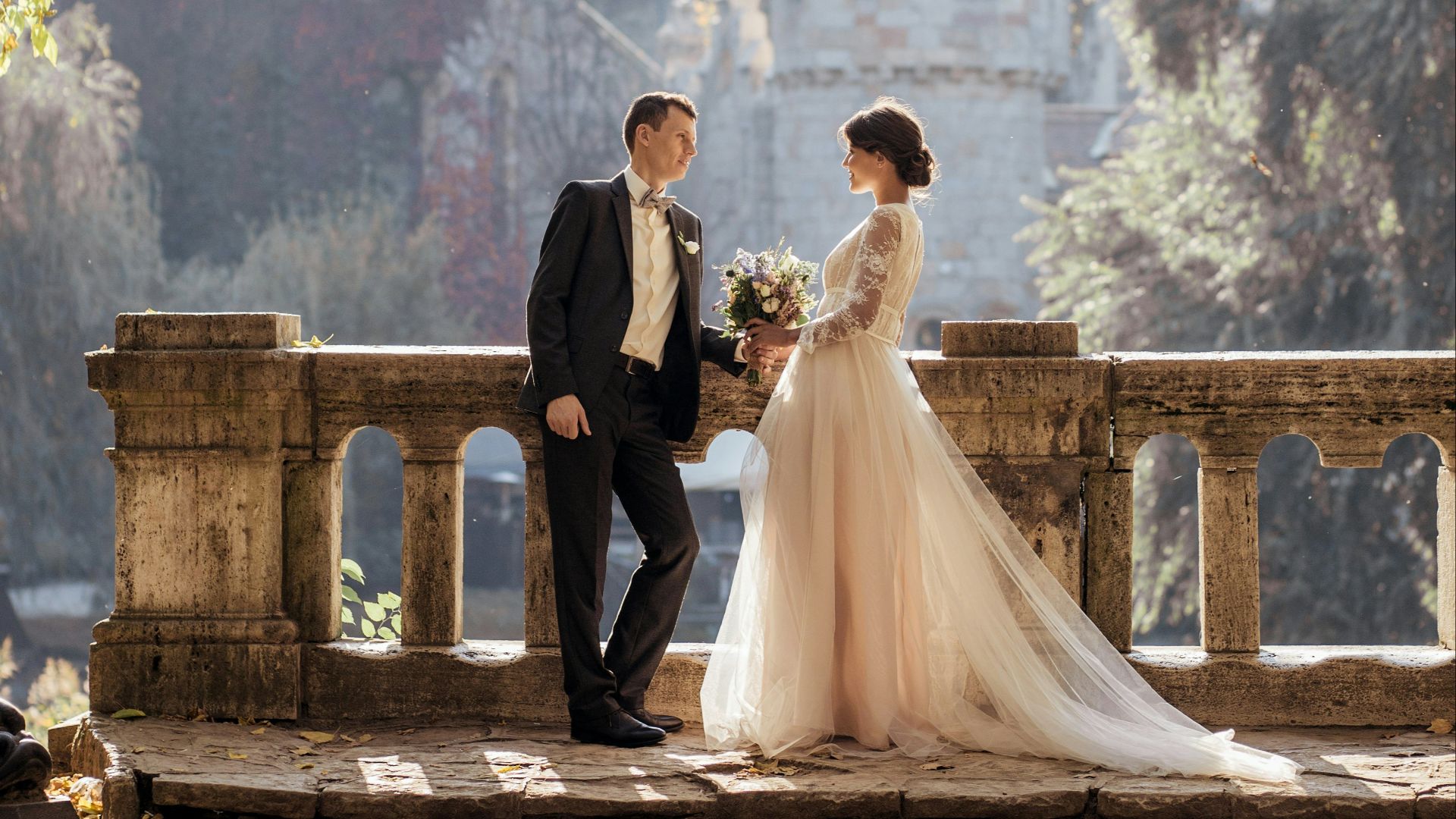 woman in white wedding dress stands in front of man in tuxedo