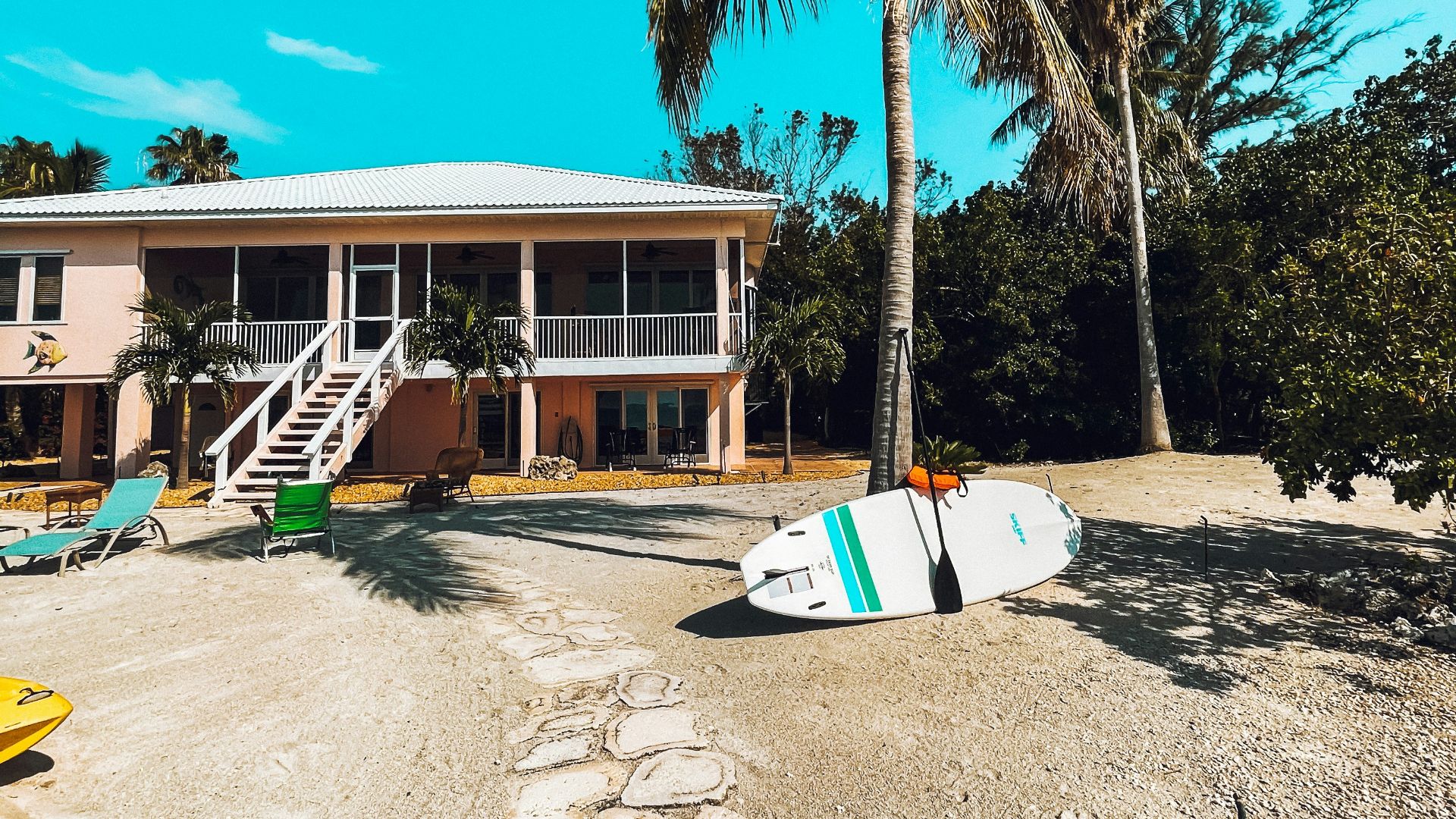 white and brown wooden house near palm trees during daytime