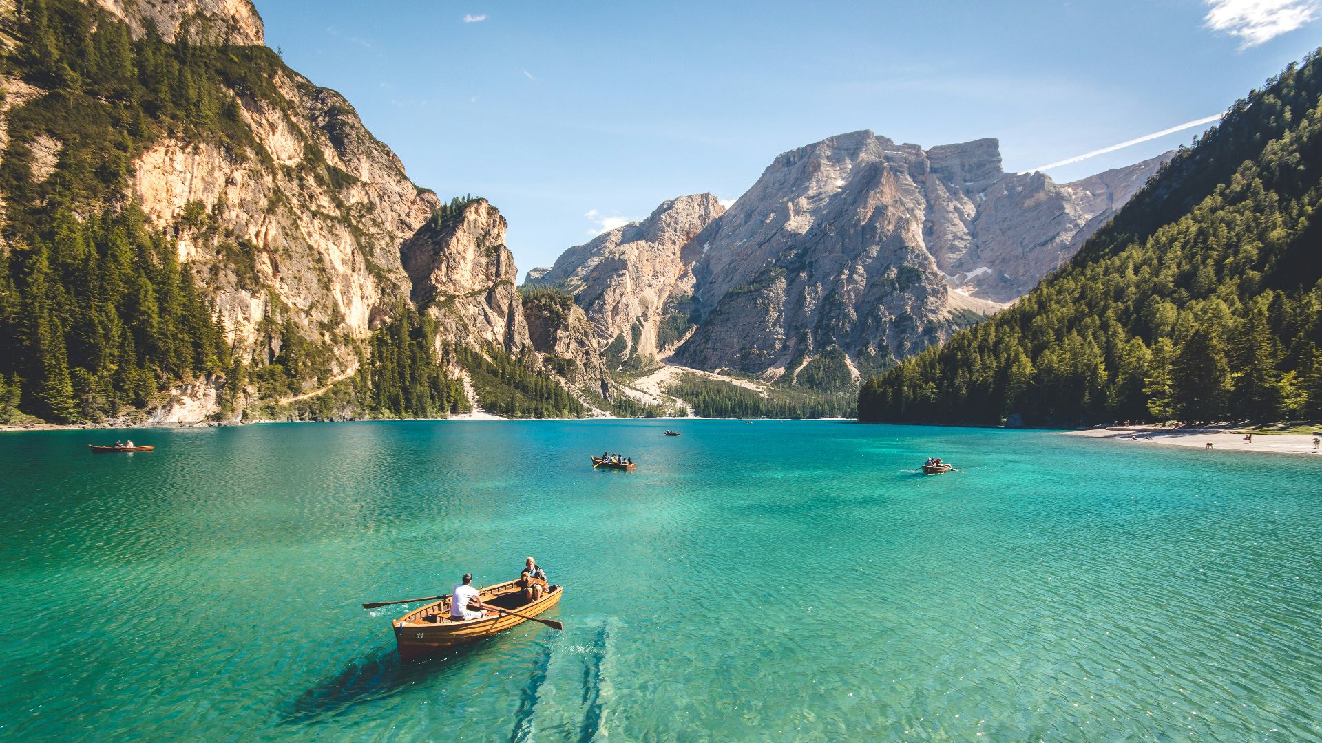 three brown wooden boat on blue lake water taken at daytime