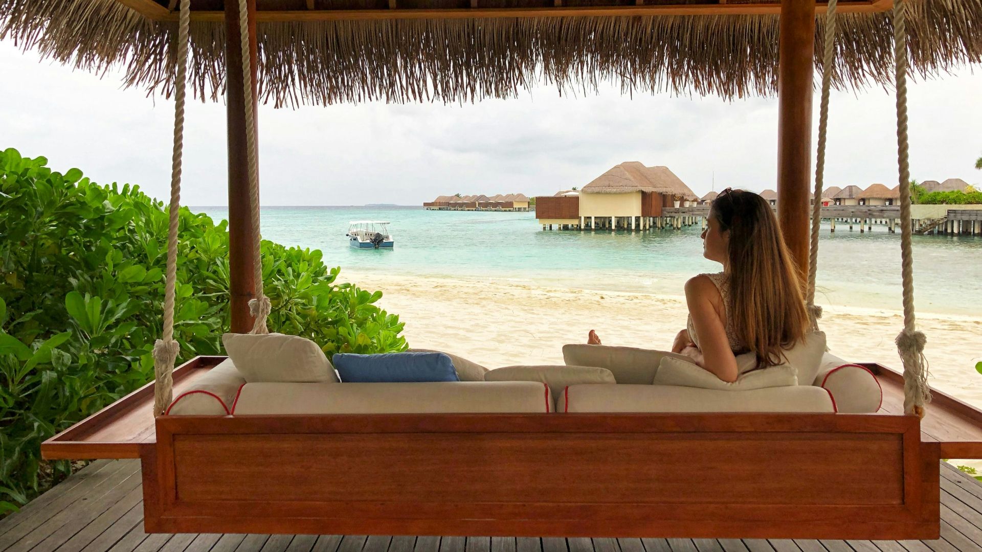 woman in white bikini lying on white bed