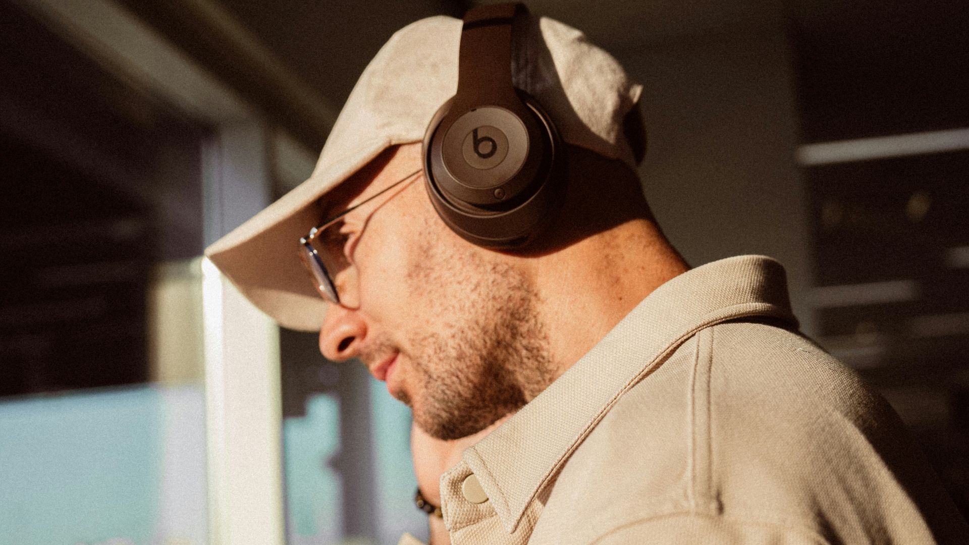 a man wearing headphones while standing next to a window