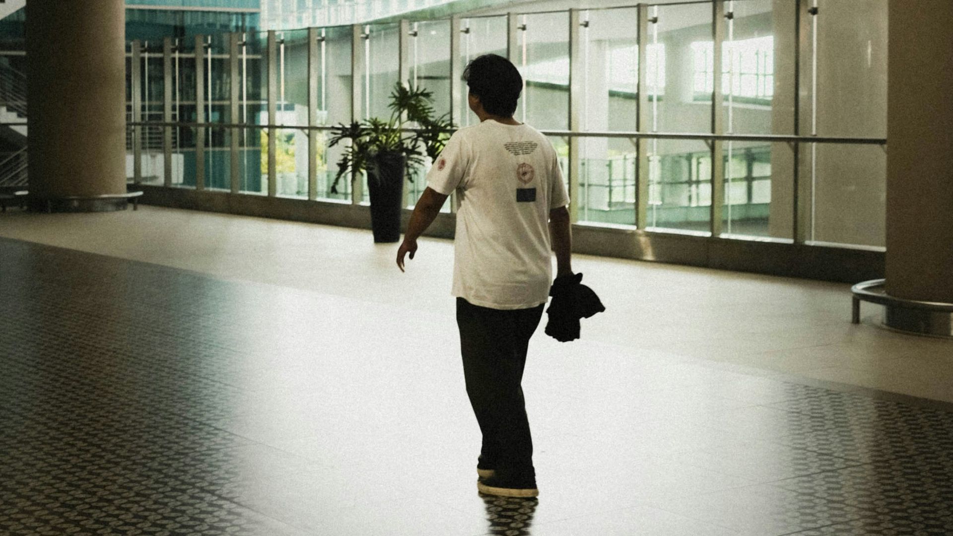 A man walking through an airport terminal at night