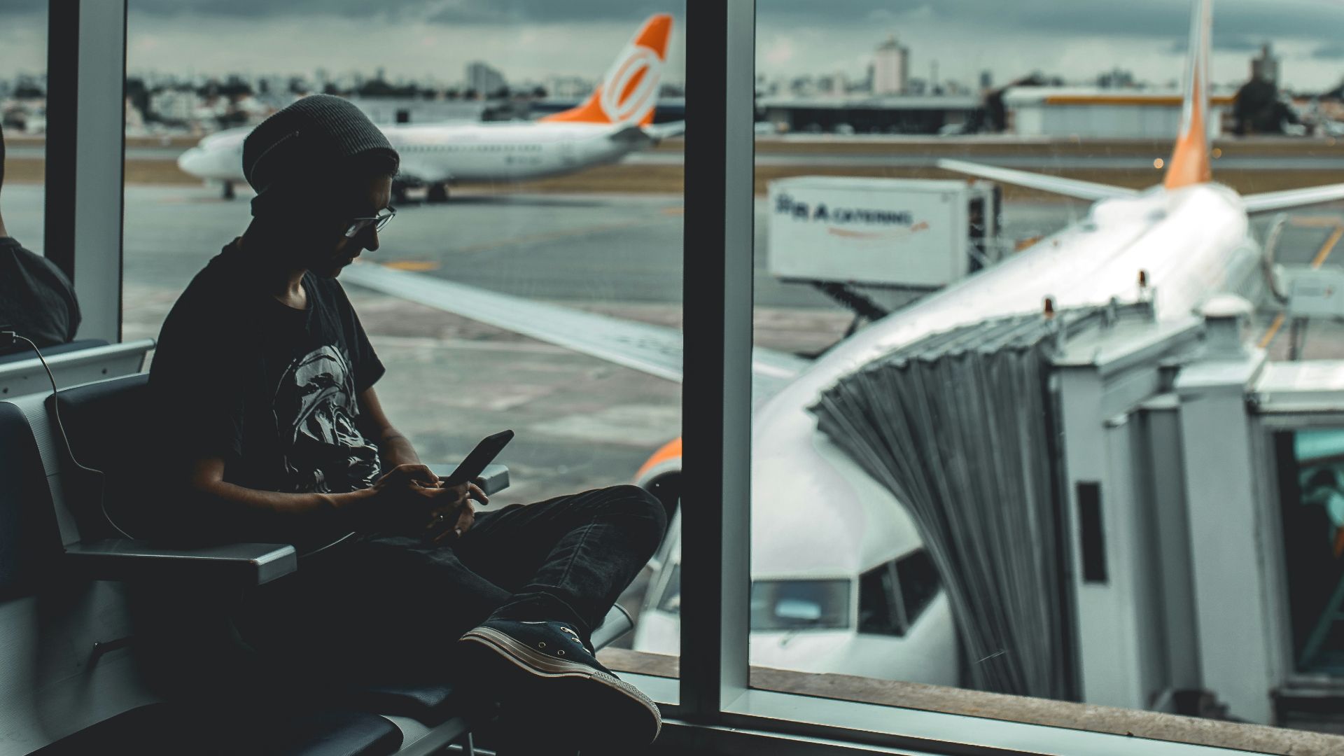 man browsing his phone in airport