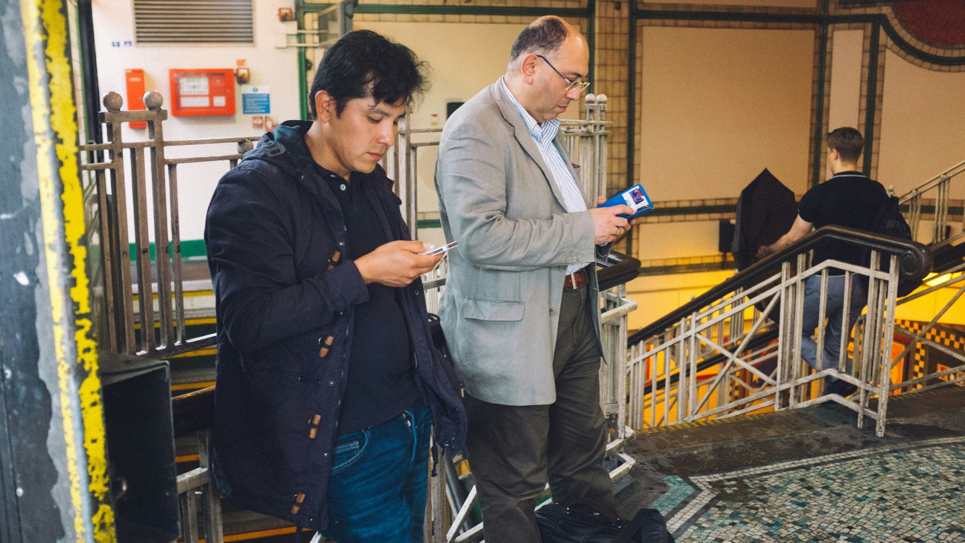 man in blue dress shirt standing beside man in gray dress shirt