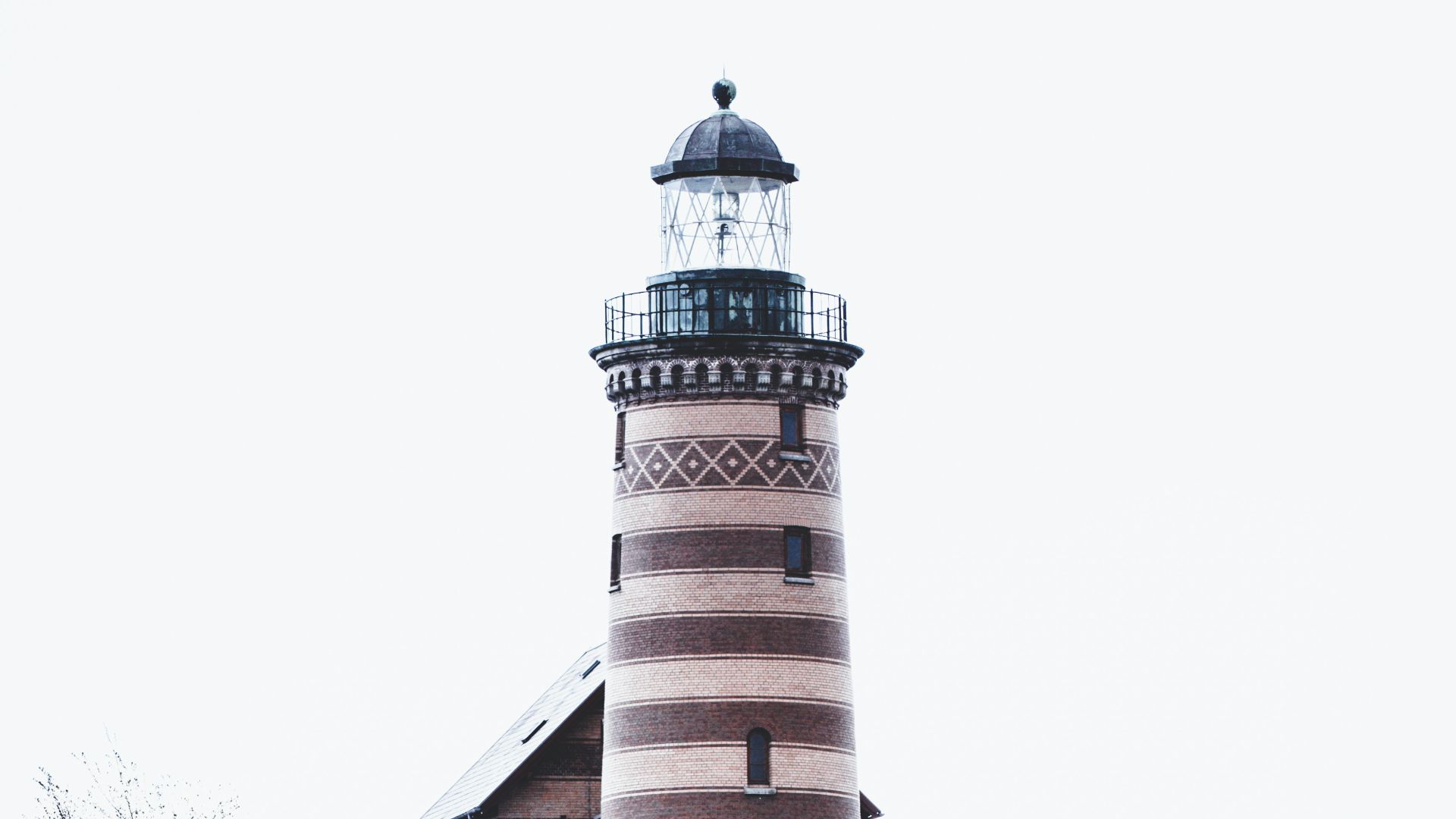 a lighthouse on top of a hill on a cloudy day
