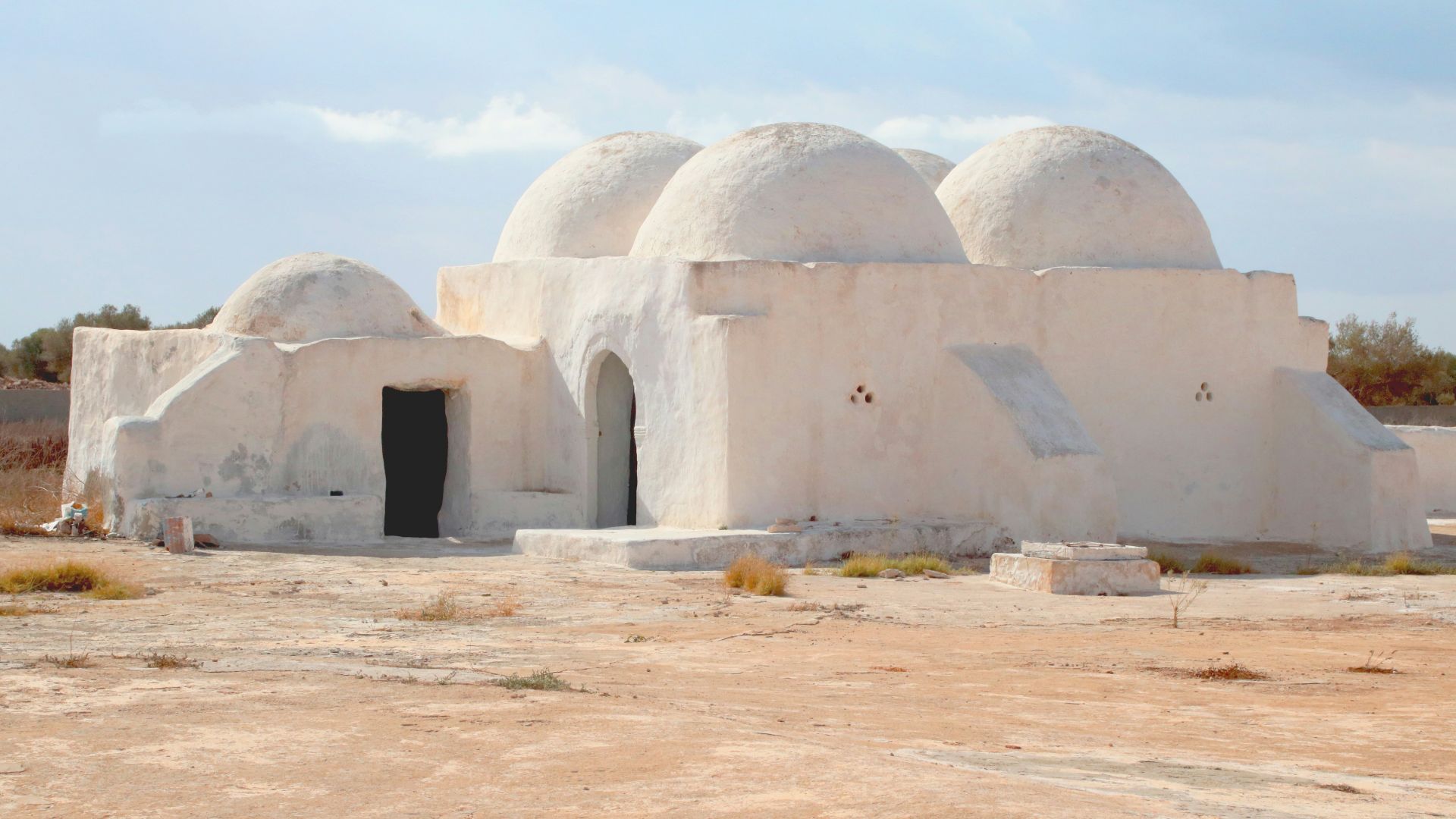 a large white building sitting in the middle of a desert