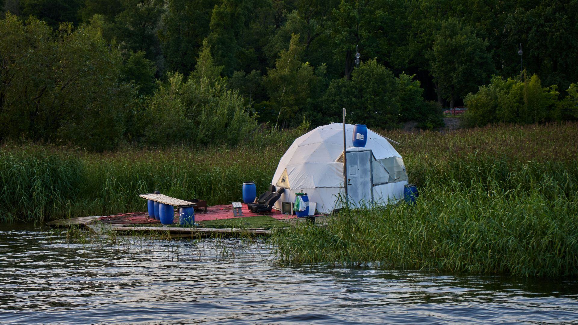 a tent is set up on the edge of a body of water