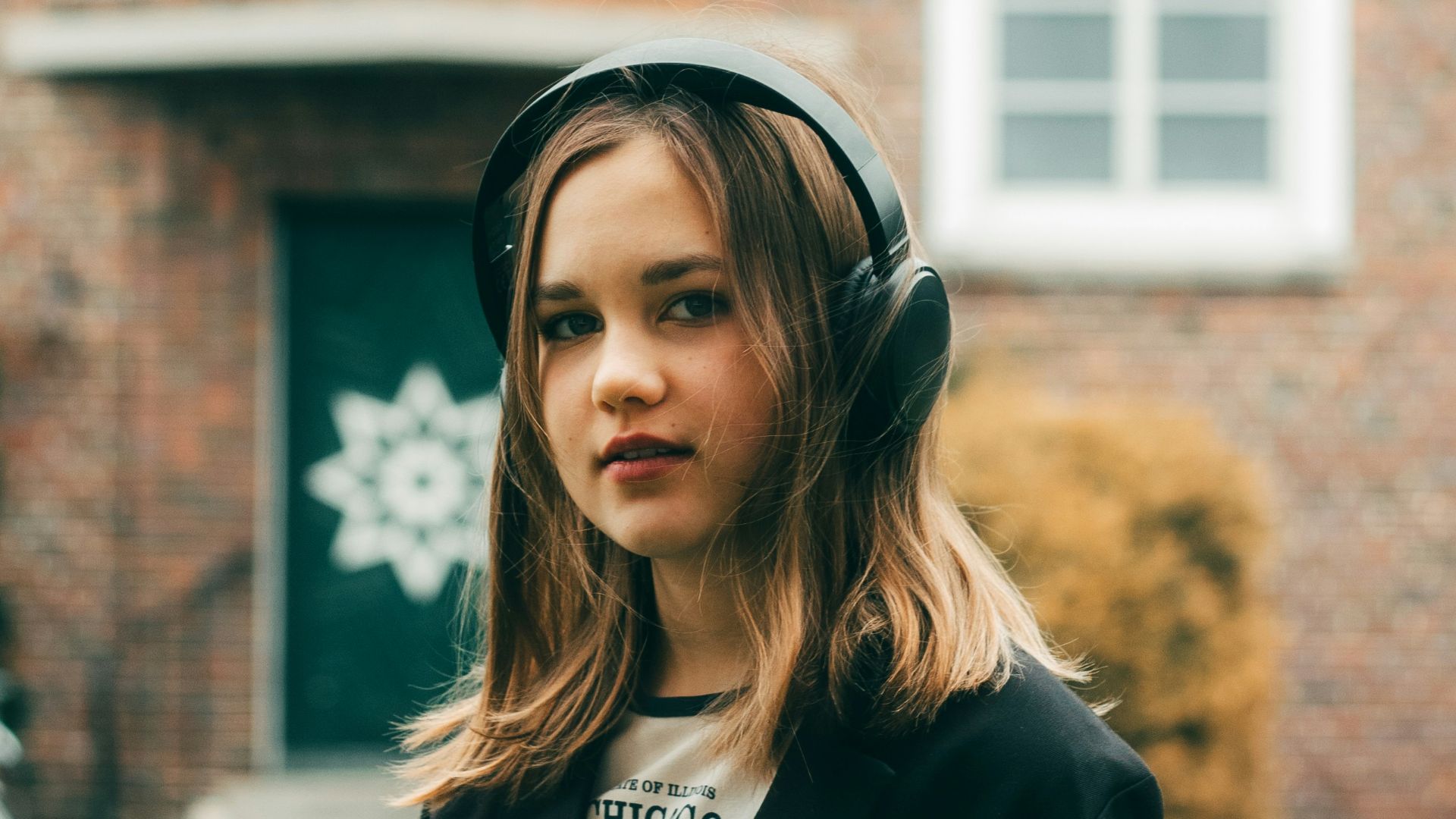 a woman standing in front of a brick building