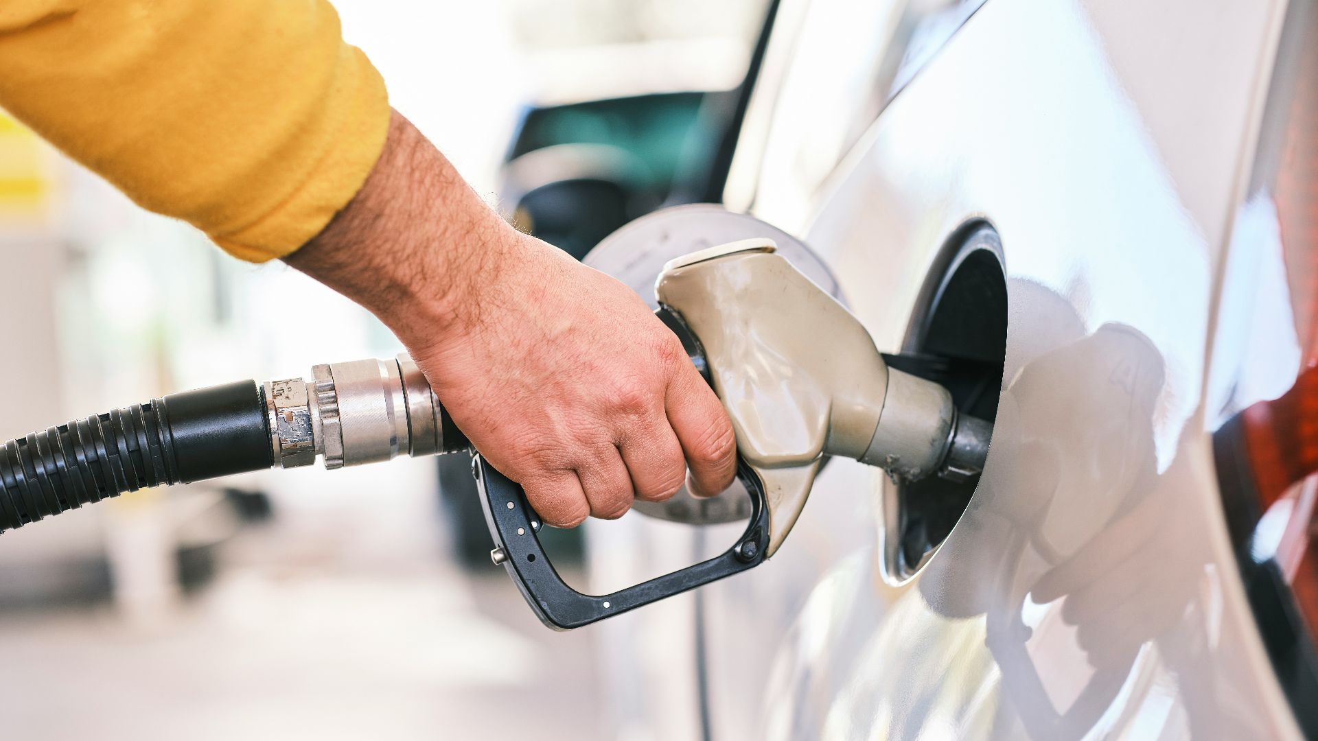 a man pumping gas into his car at a gas station