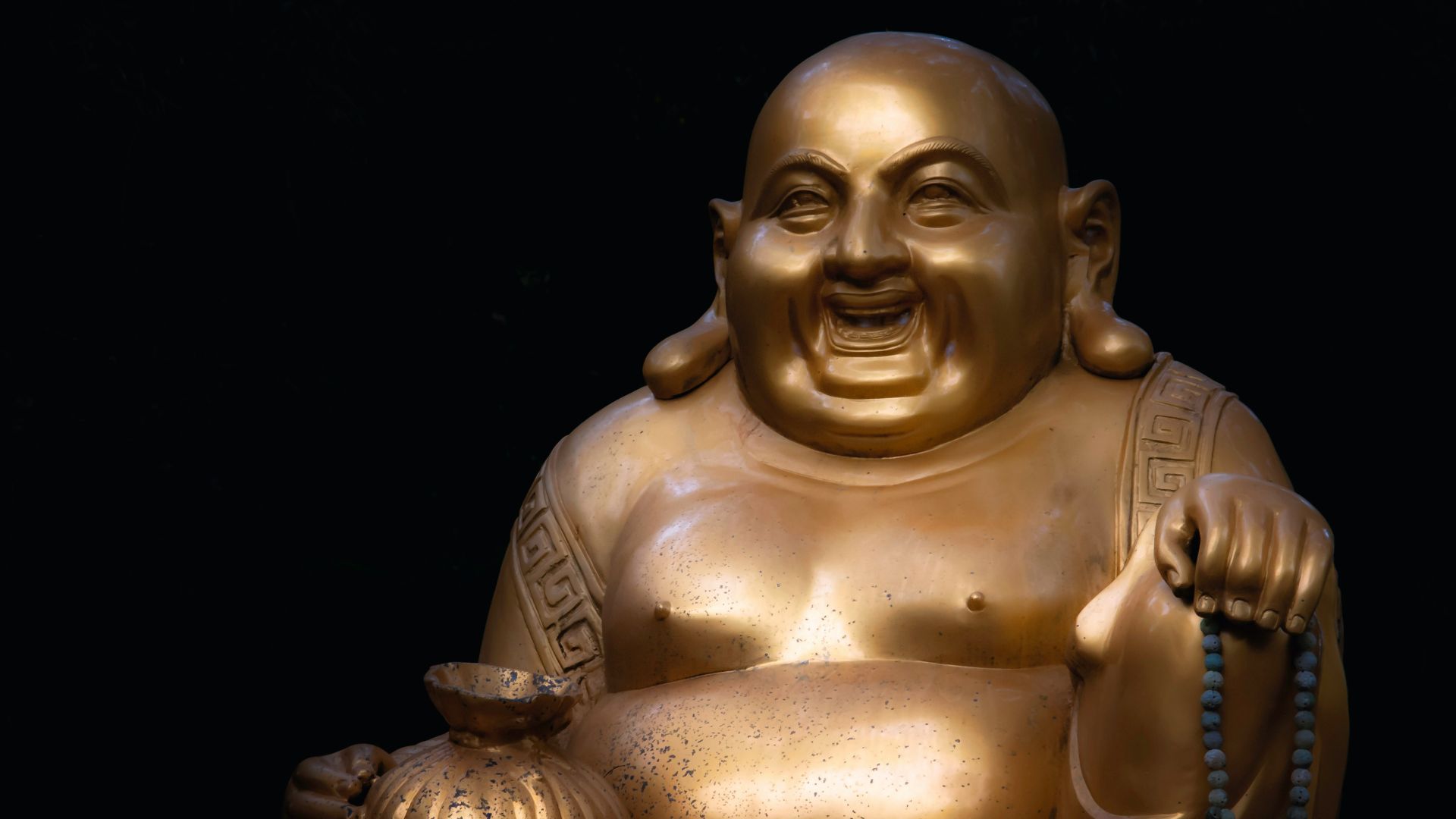 a golden statue of a person holding a book