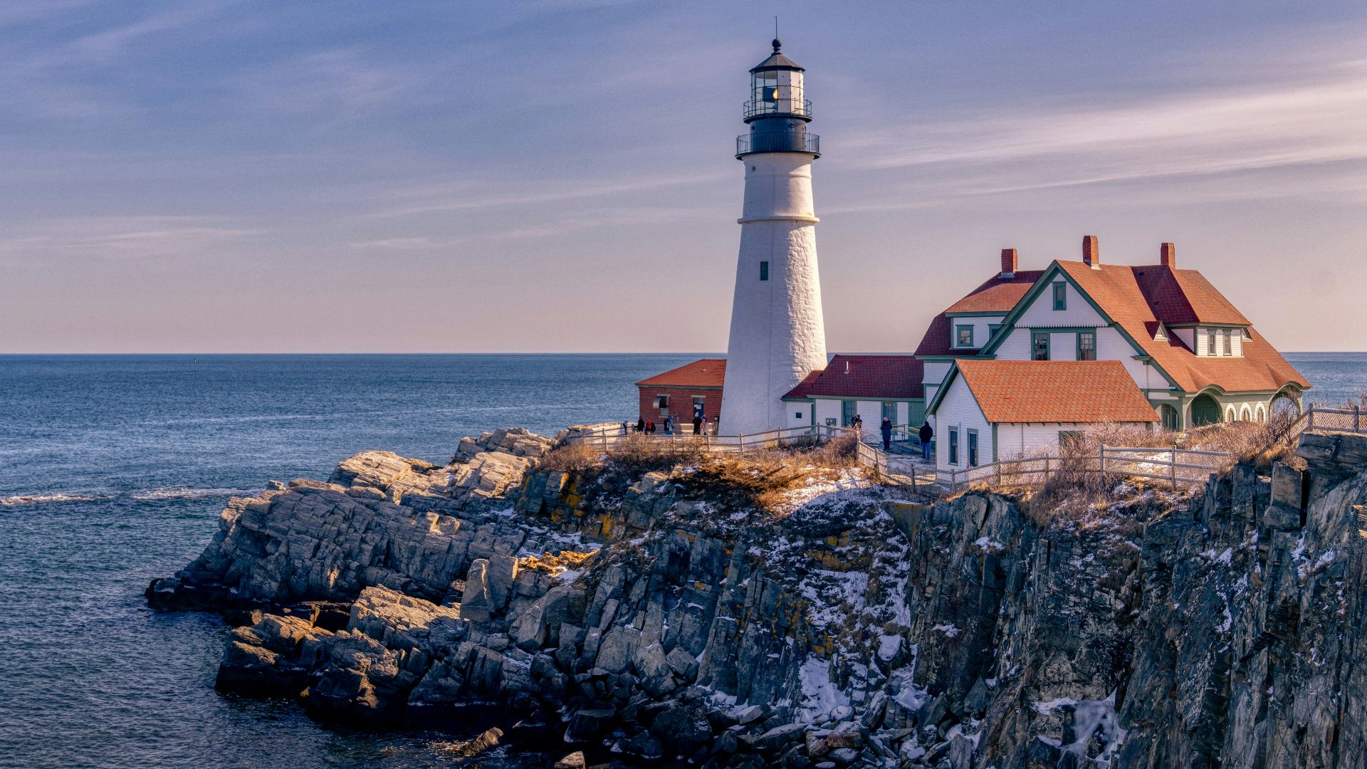 white and brown concrete house beside sea under blue sky during daytime