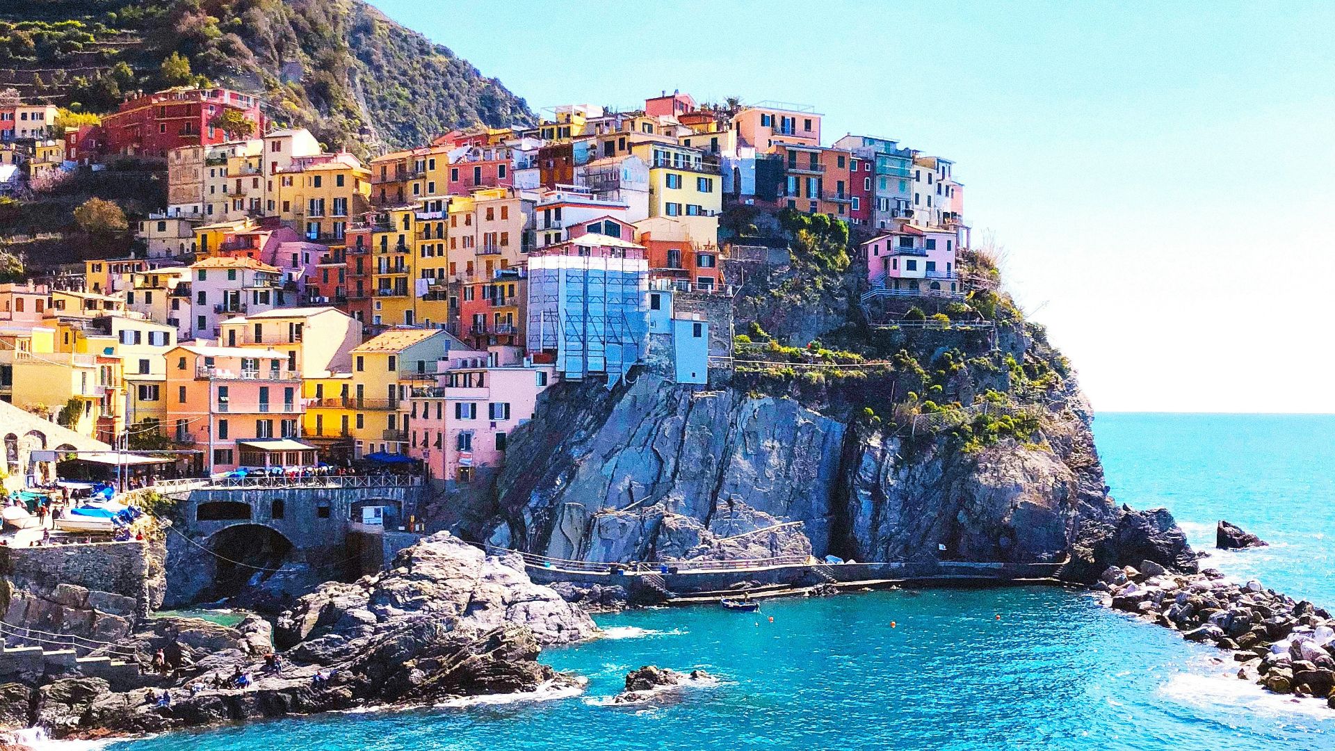 houses on mountain beside sea during daytime