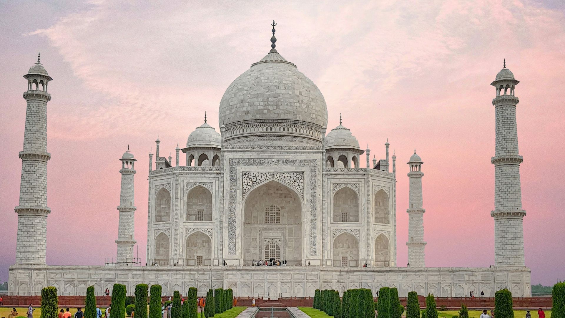 man in black jacket standing in front of white concrete building during daytime