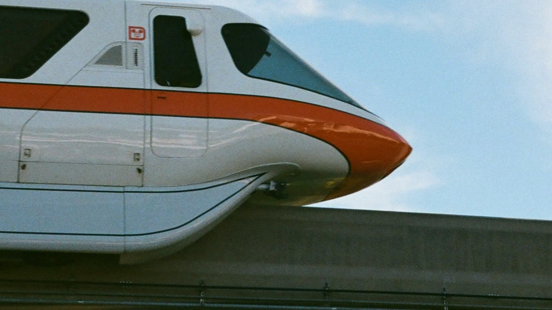 A monorail going over a bridge in a park