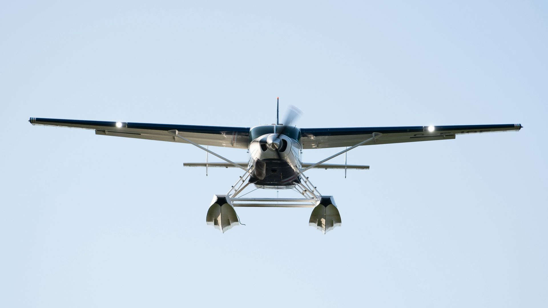 a small propeller plane flying through a blue sky
