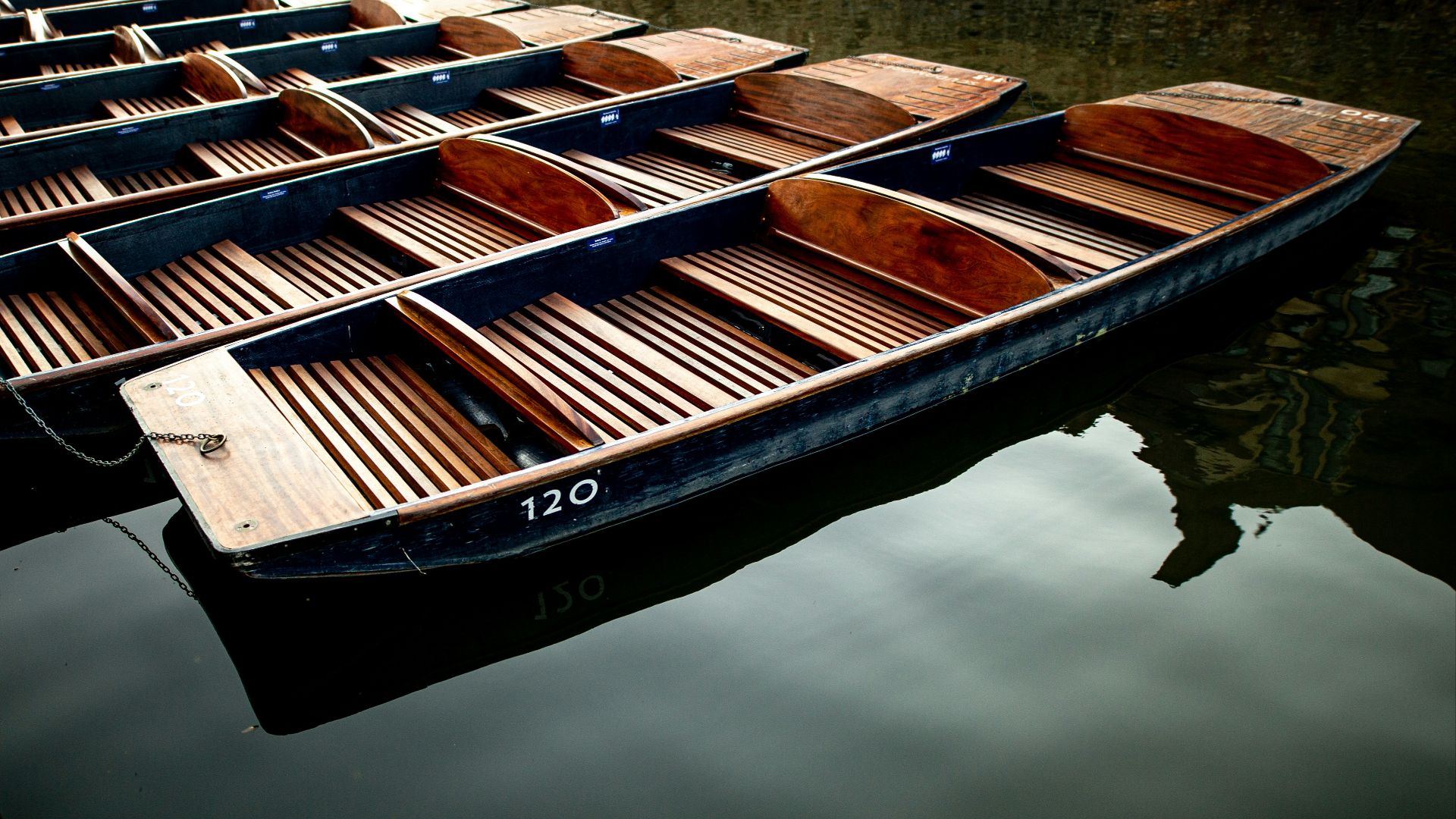 a row of wooden boats floating on top of a body of water