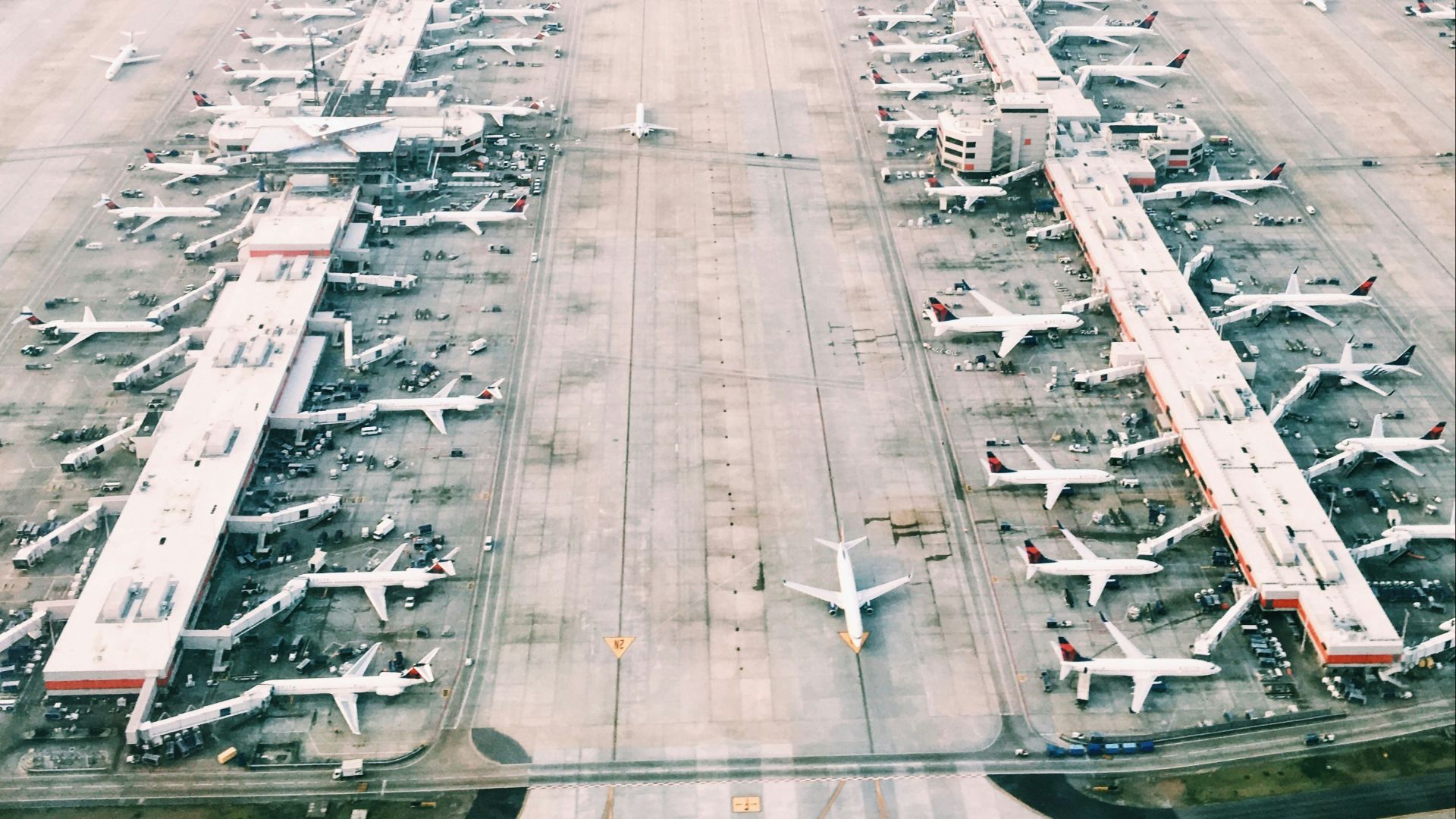 aerial view of airport with lots of airplanes during daytime