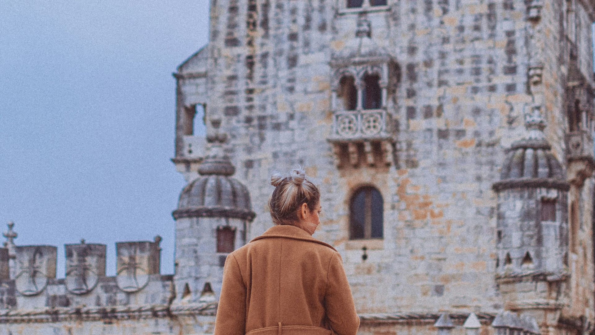 a woman standing in front of a castle
