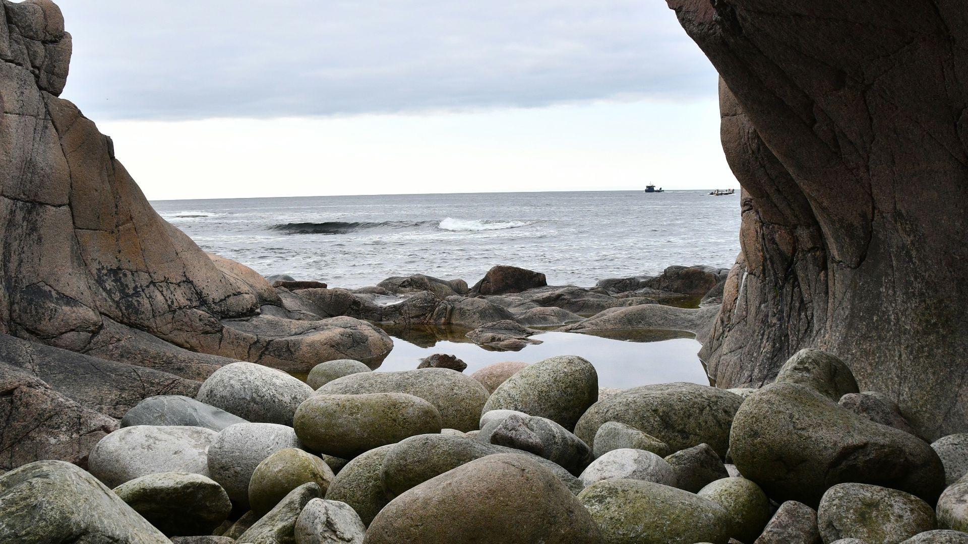 a rocky beach area with large rocks and a body of water