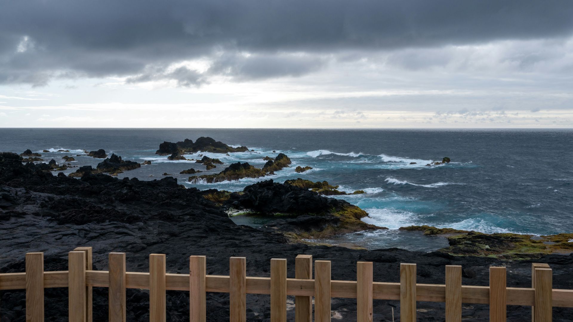 a wooden fence next to a body of water