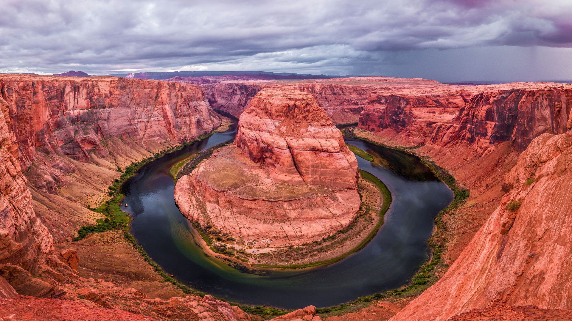 brown mountain with river under cloudy sky