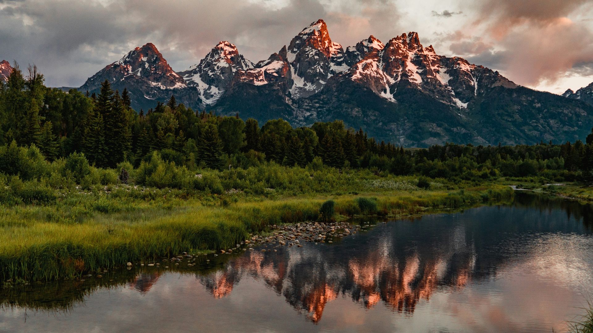 green trees near lake and snow covered mountain during daytime