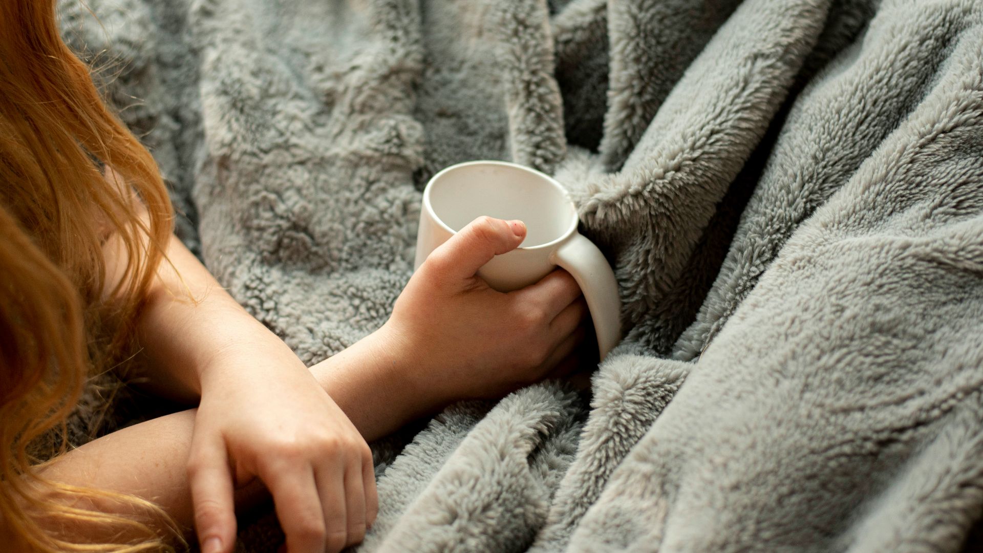 woman holding white ceramic mug