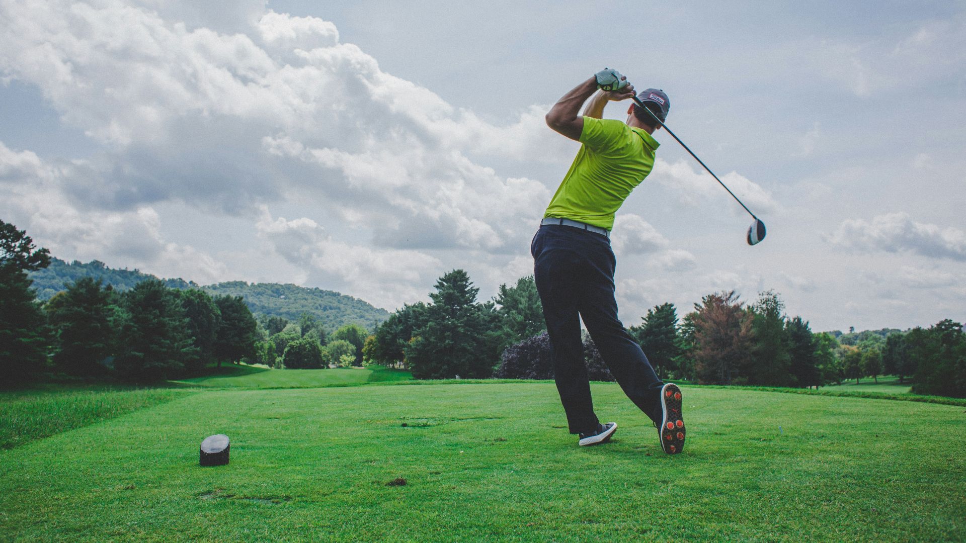 photo of man swinging golf driver