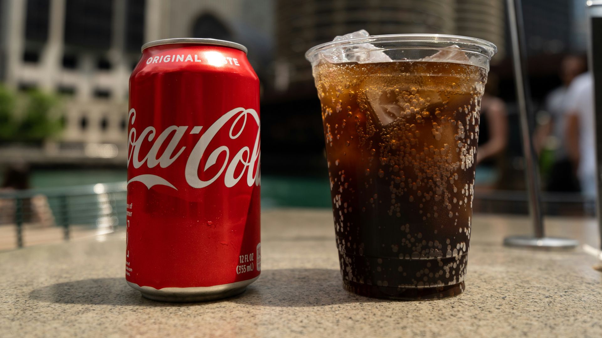 Coca-Cola soda tin can and cup on table close-up photography