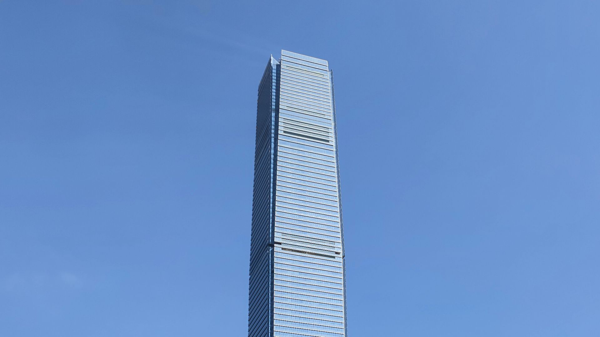 a tall building towering over a city filled with tall buildings