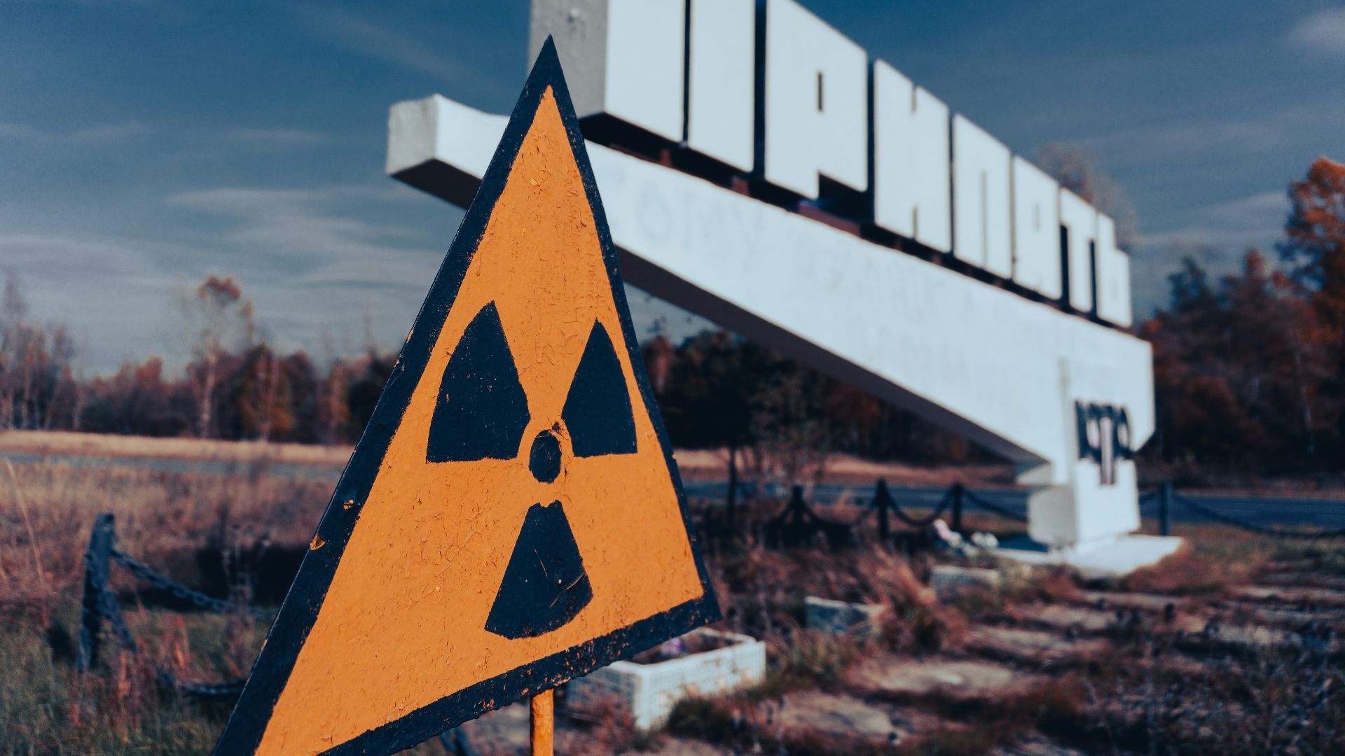 a yellow and black sign sitting on the side of a road