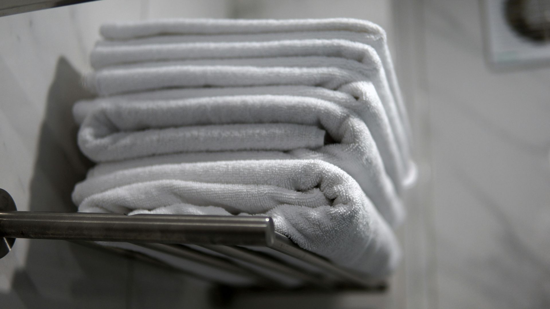 A stack of folded towels sitting on a towel rack