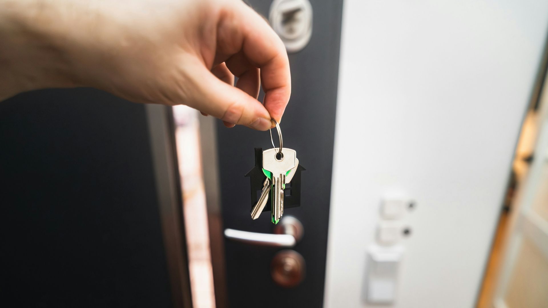 A person is holding a key to a door
