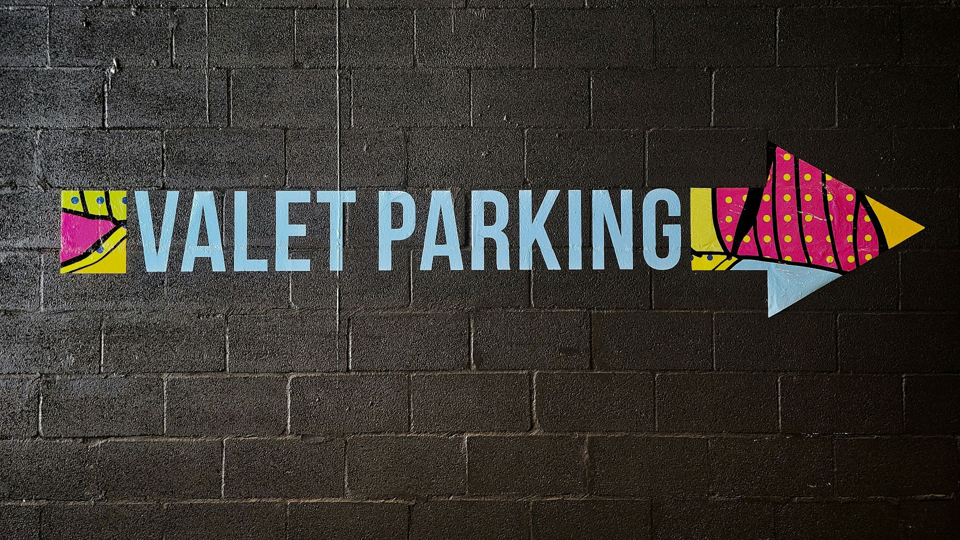 a painted sign on a brick wall that says valet parking