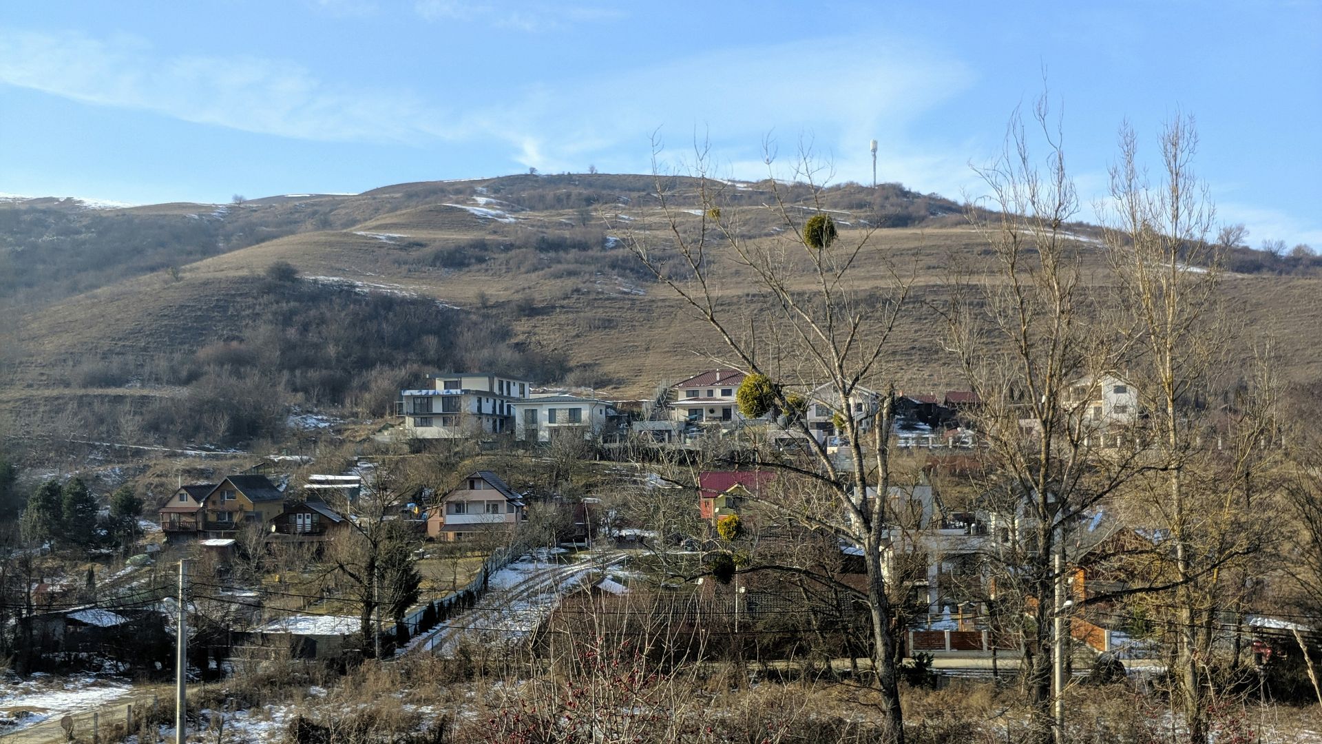 a snow covered field with a hill in the background