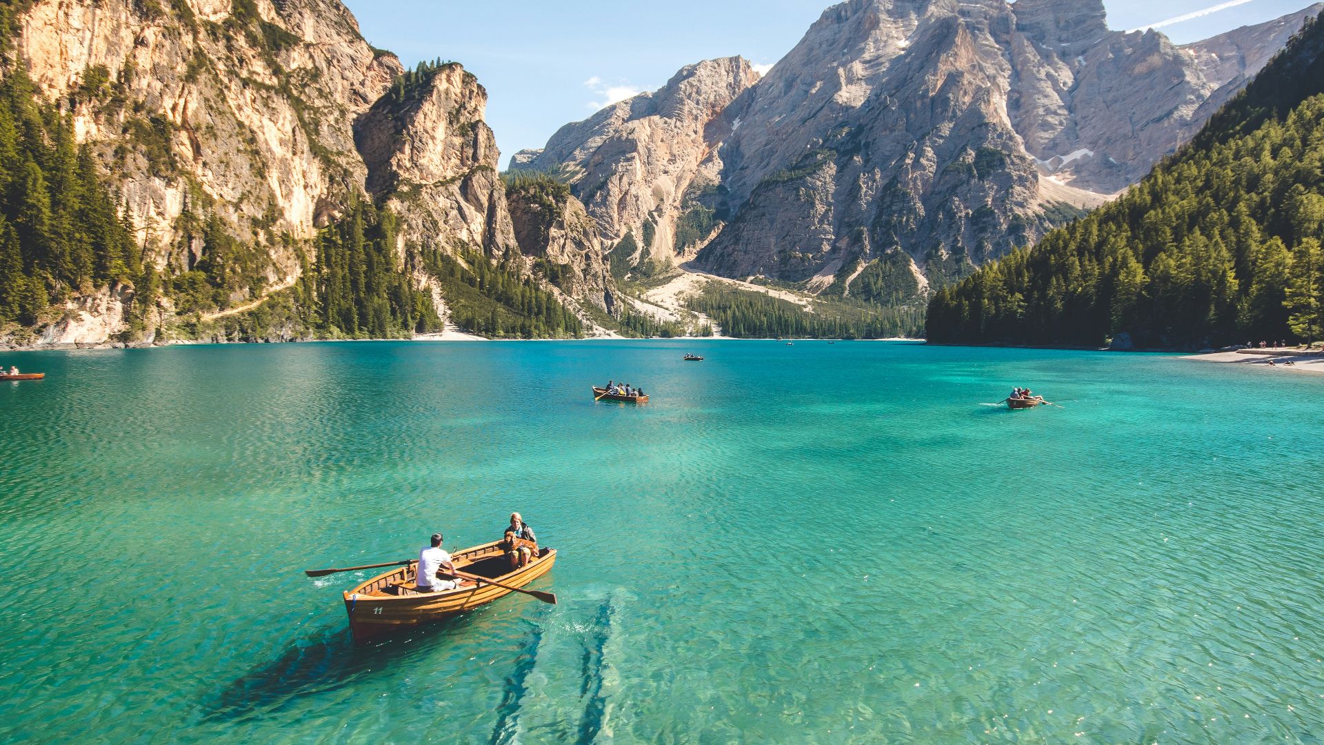 three brown wooden boat on blue lake water taken at daytime