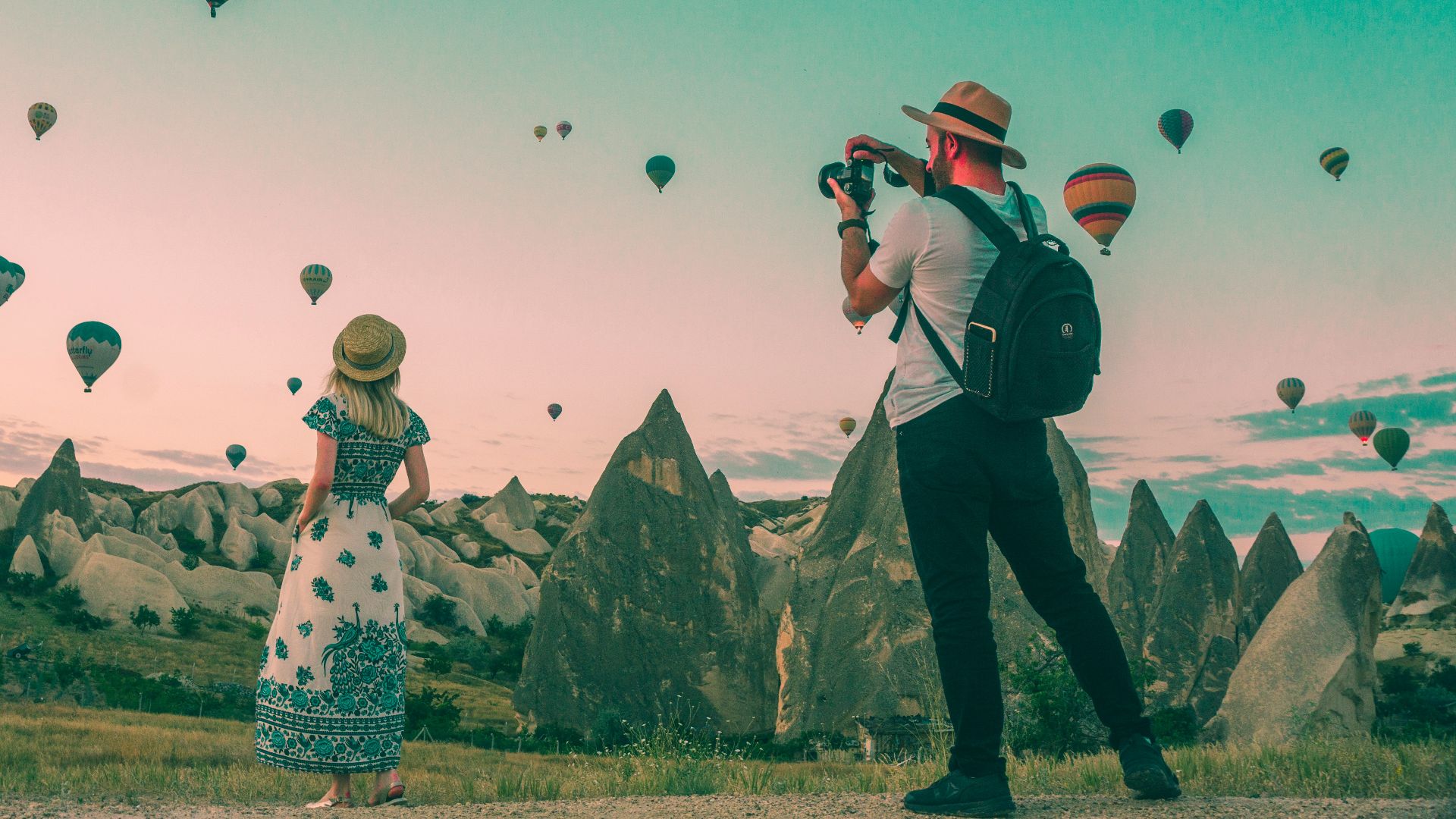 man taking photo of hot air balloons