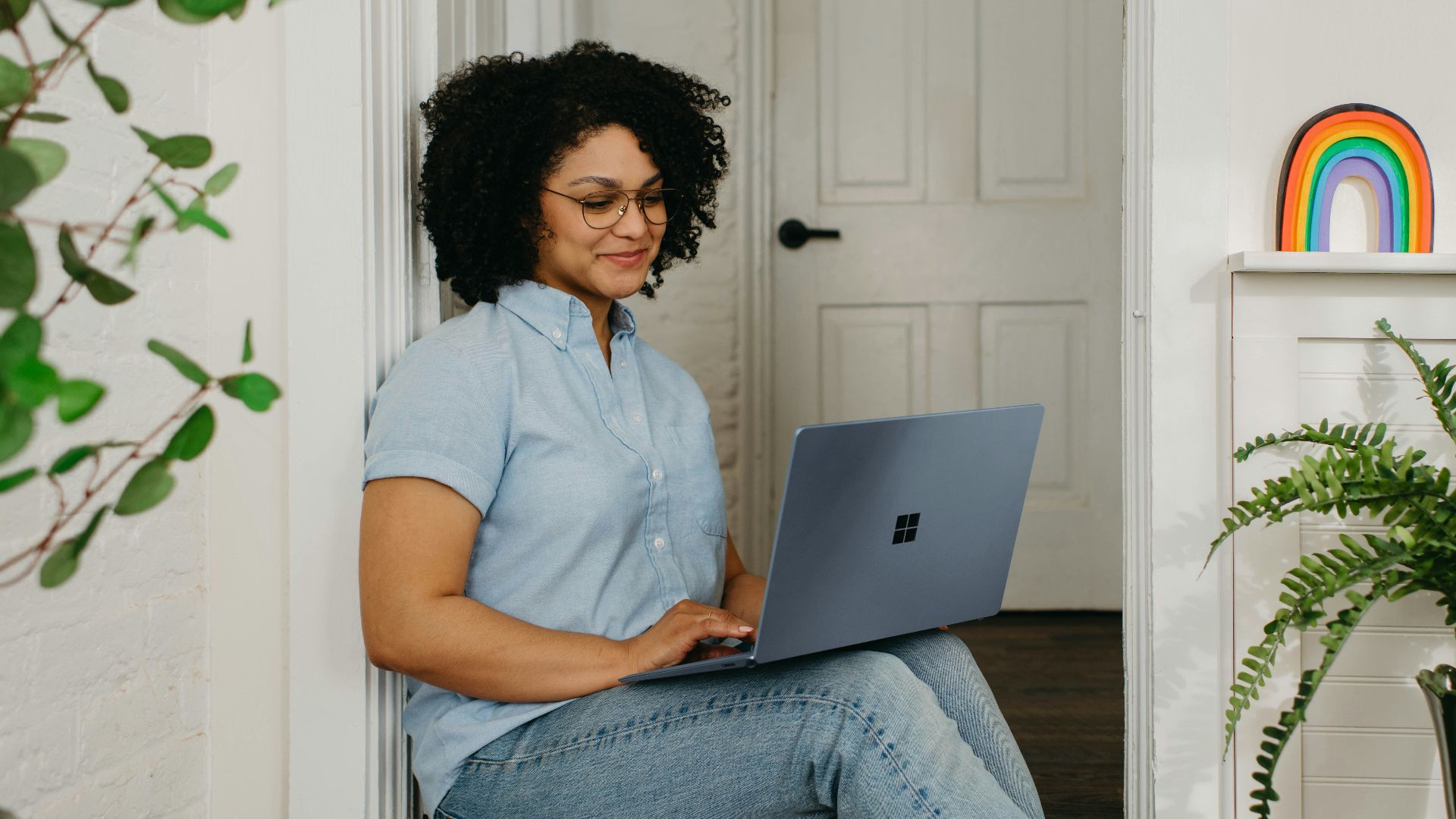 a woman sitting on the floor using a laptop