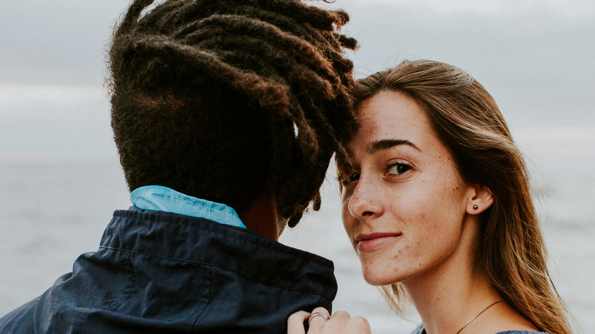 woman in blue long sleeve shirt beside woman in gray long sleeve shirt