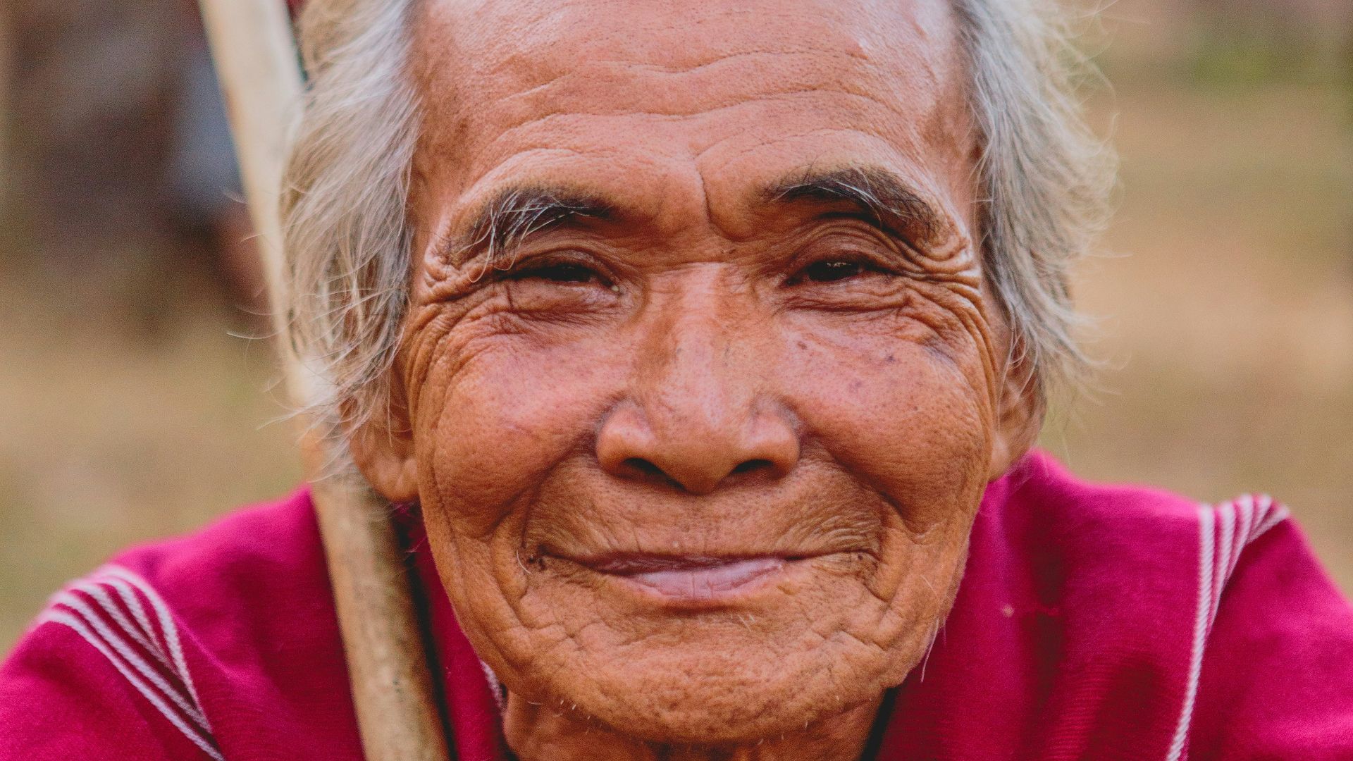 man holding brown stick smiling