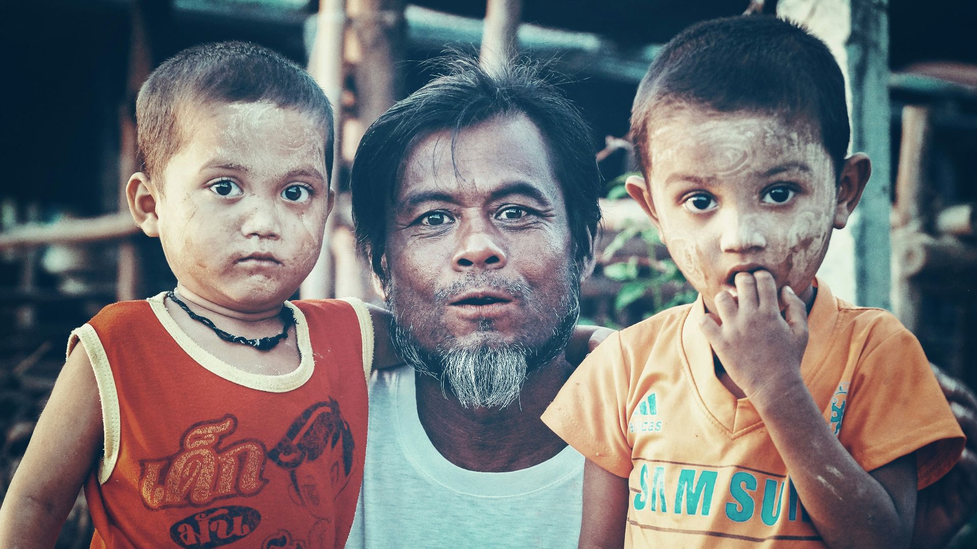 man standing between two boys