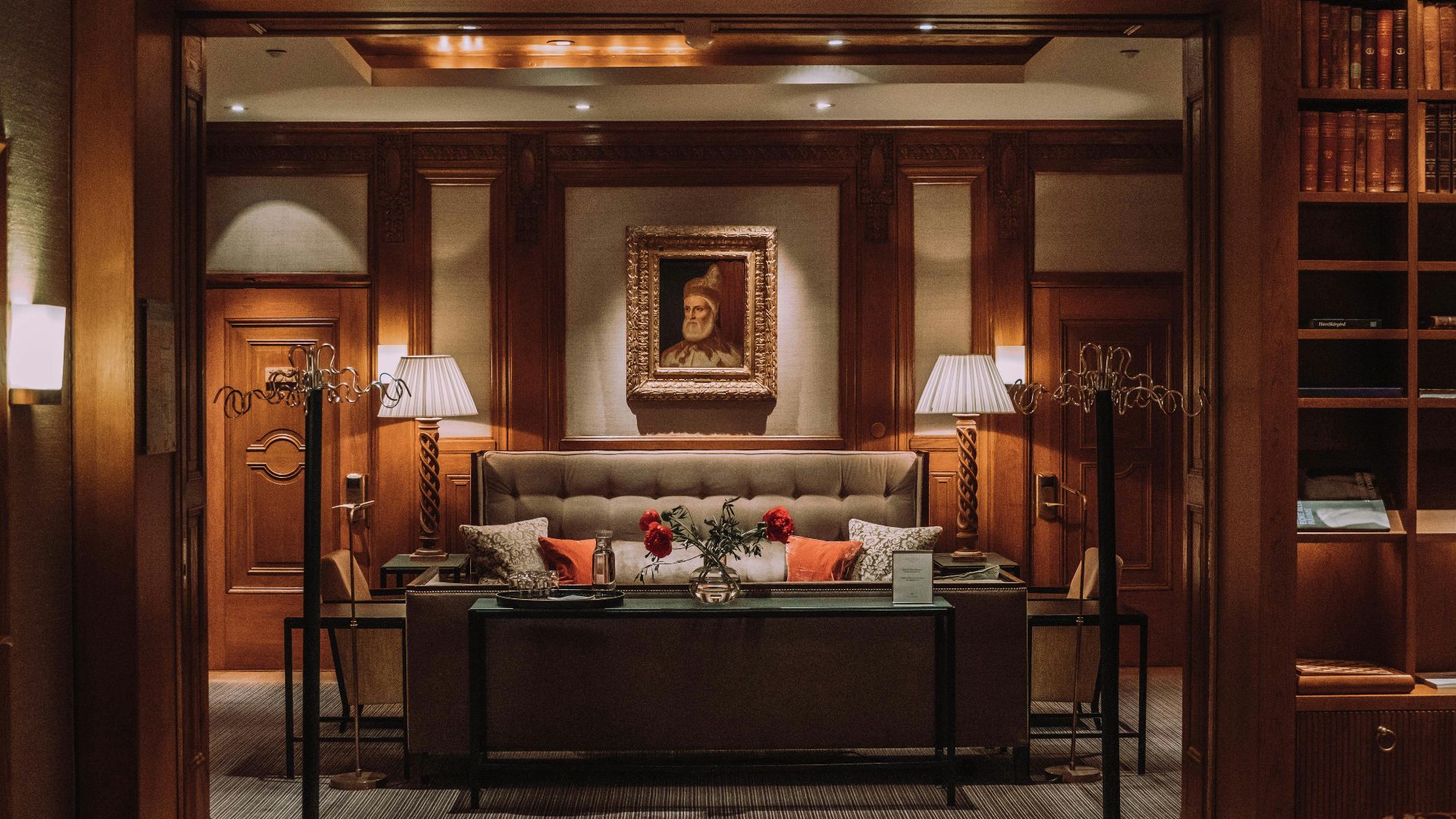 brown wooden bed frame with white and red floral bed linen