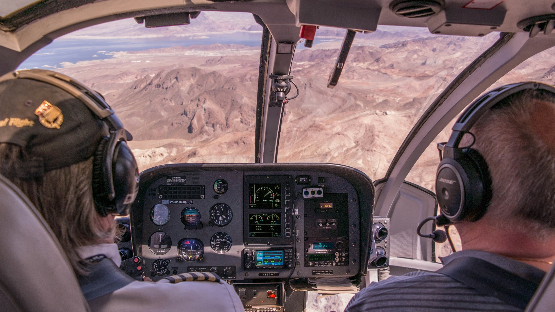 two person riding plane near mountains during daytime