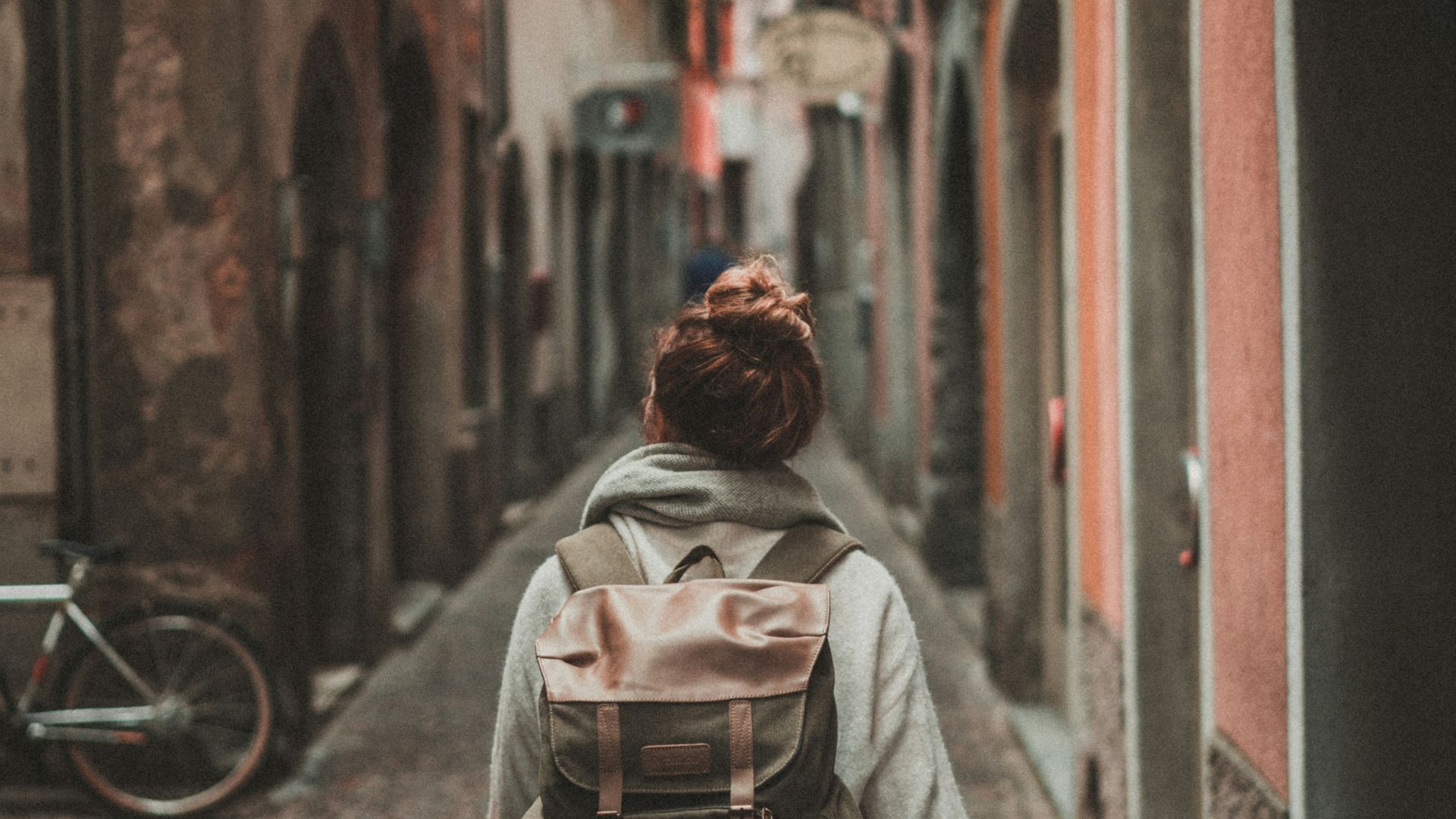 woman walking on street surrounded by buildings