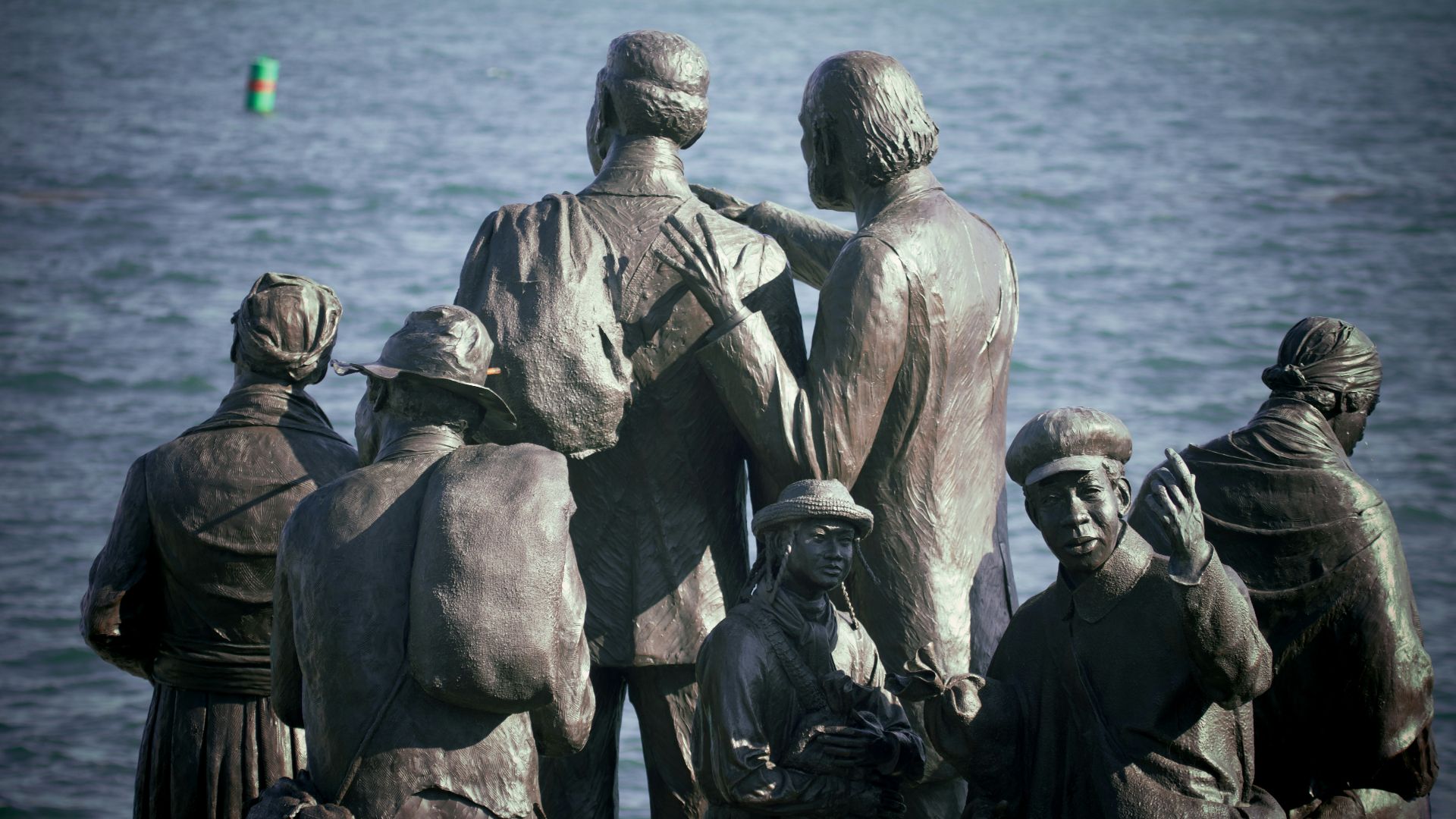 a group of people standing next to a body of water