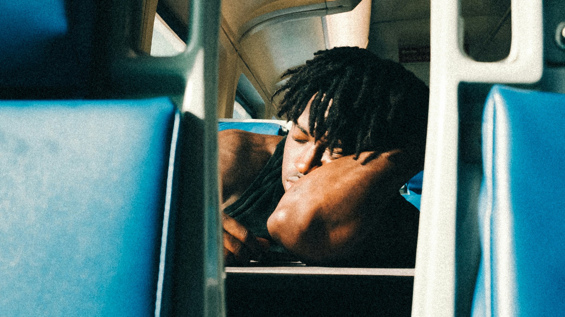 a man sitting on a train next to a window
